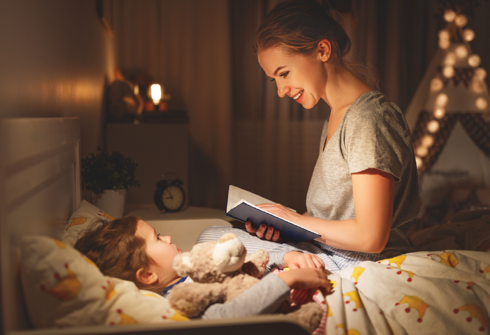 mom reading to daughter in bed with teddy bear.PNG