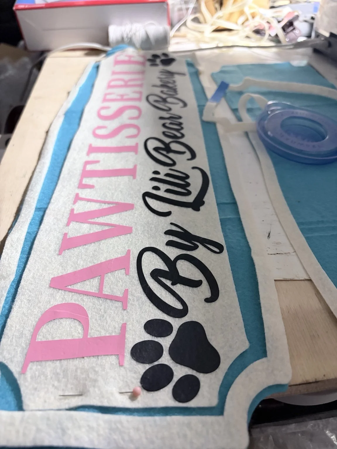 Handmade Pawtisserie by Lili Bear Bakery tabletop sign featuring pink and black lettering, a paw print, and turquoise accents on a white backgroun