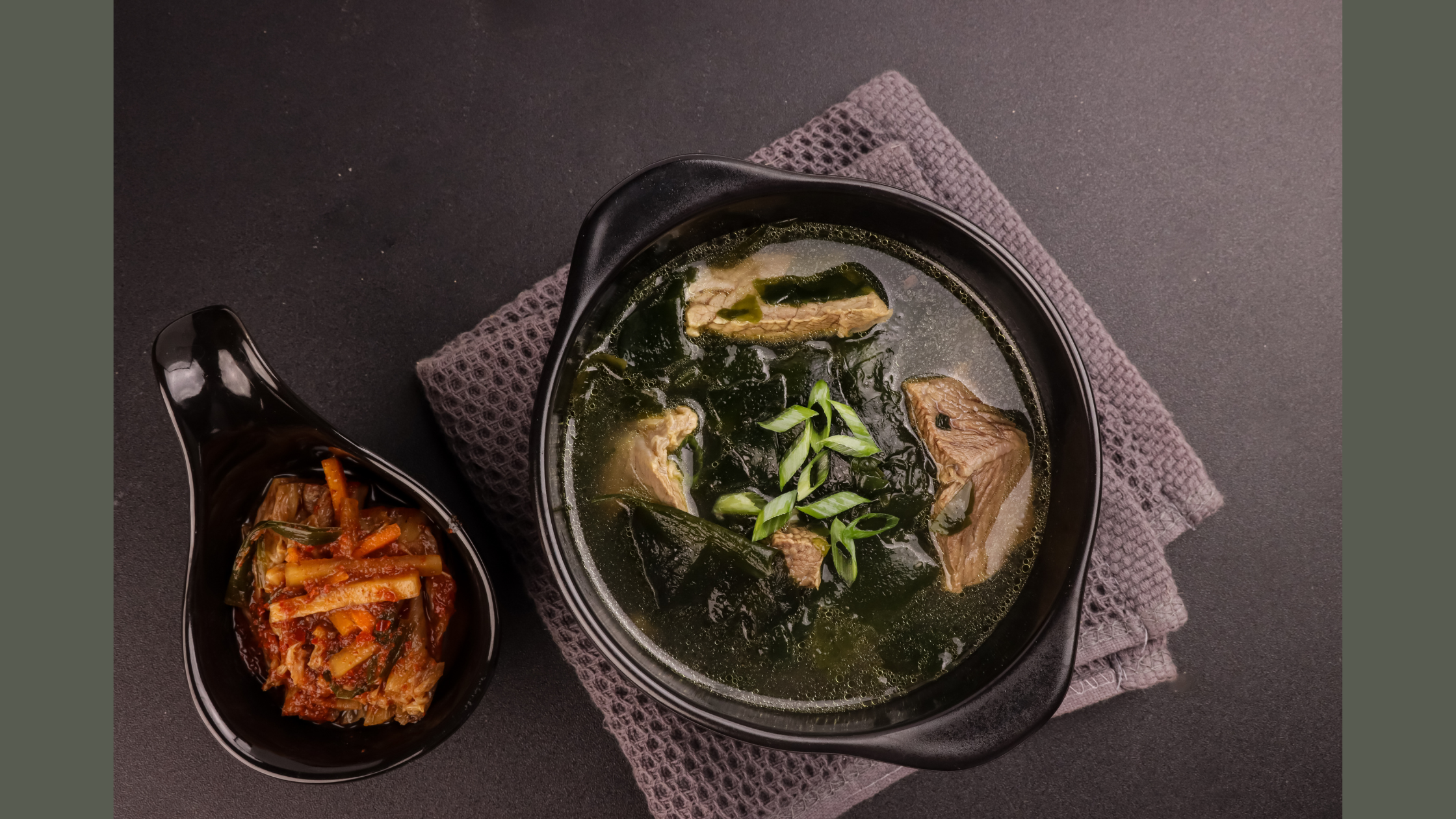 Bowl of Miyeokguk (Korean seaweed soup) with rehydrated seaweed and sliced beef in clear broth