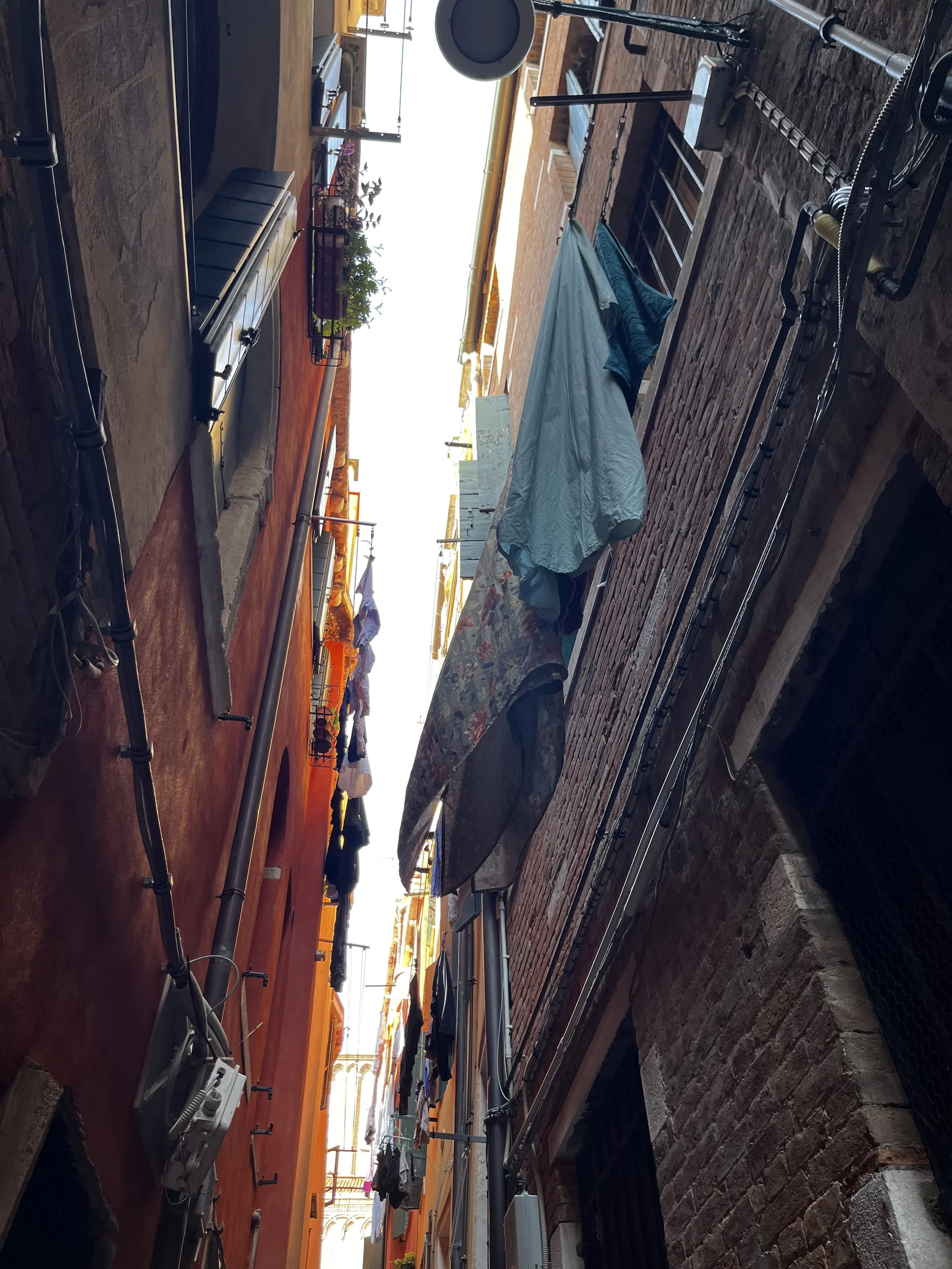 Laundry hanging between buildings in a narrow Venice street