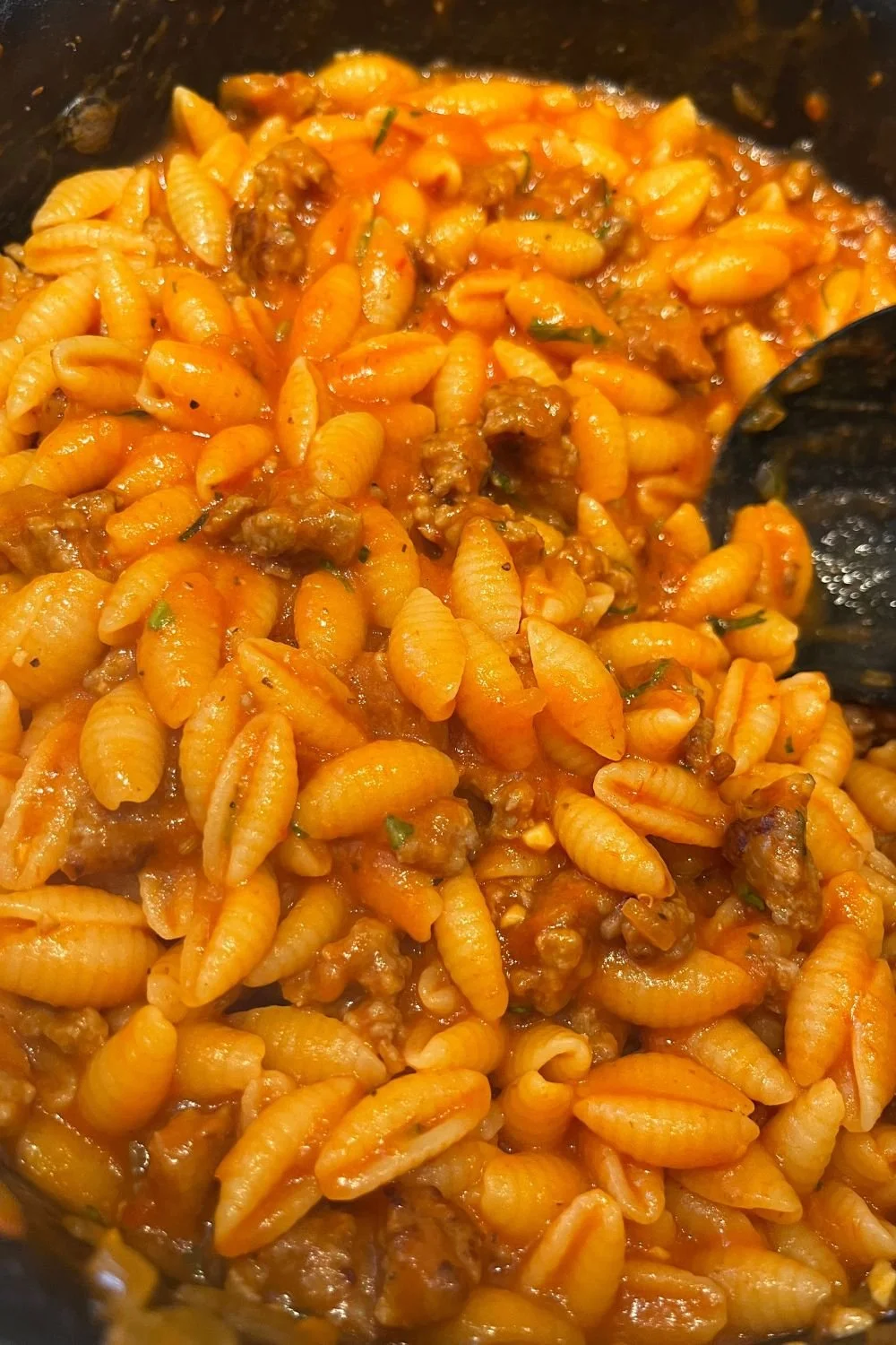 Pasta tossed in sauce, close-up in the pot