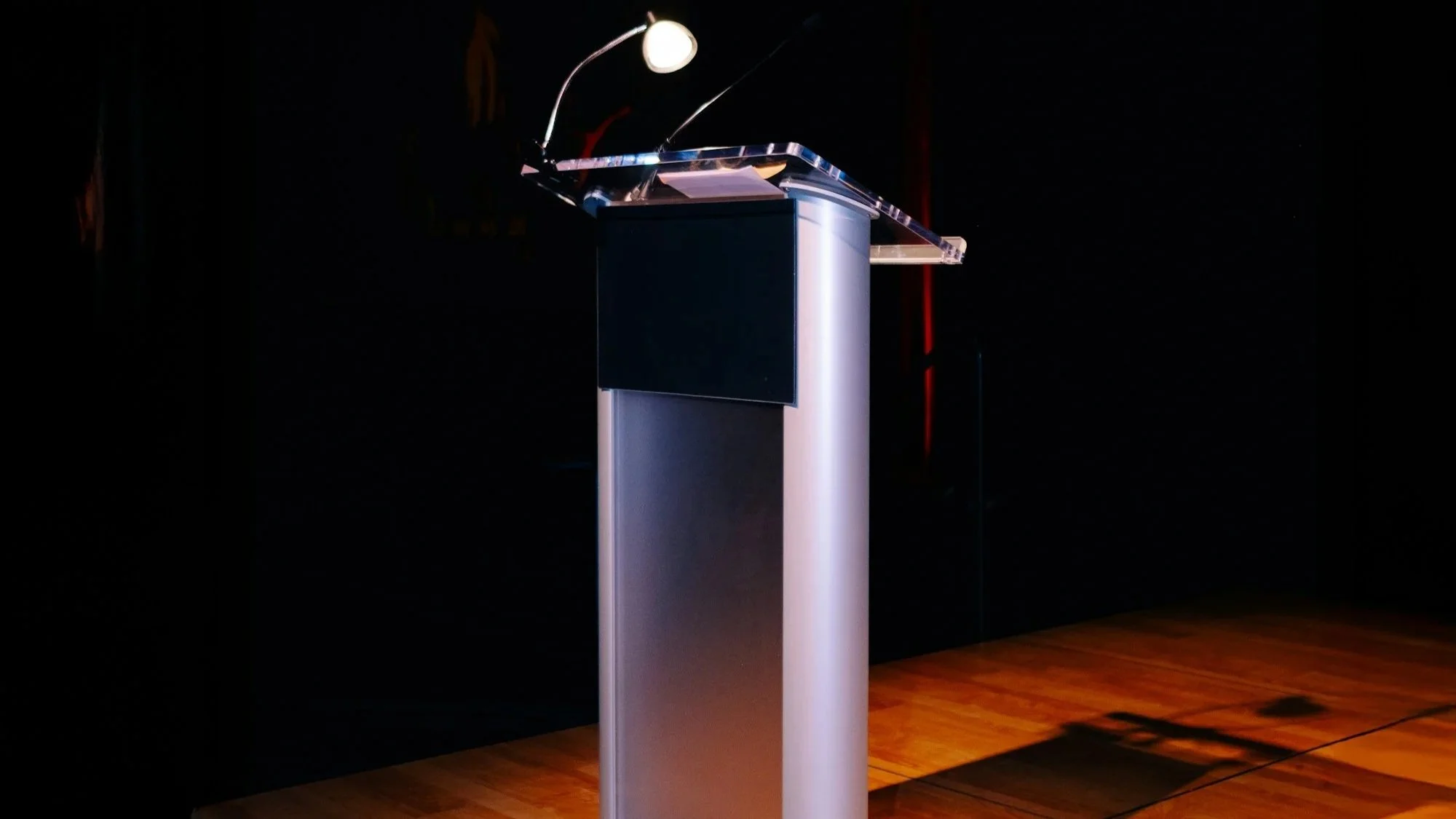 Podium with microphone and presentation equipment on a stage for a corporate or conference event.