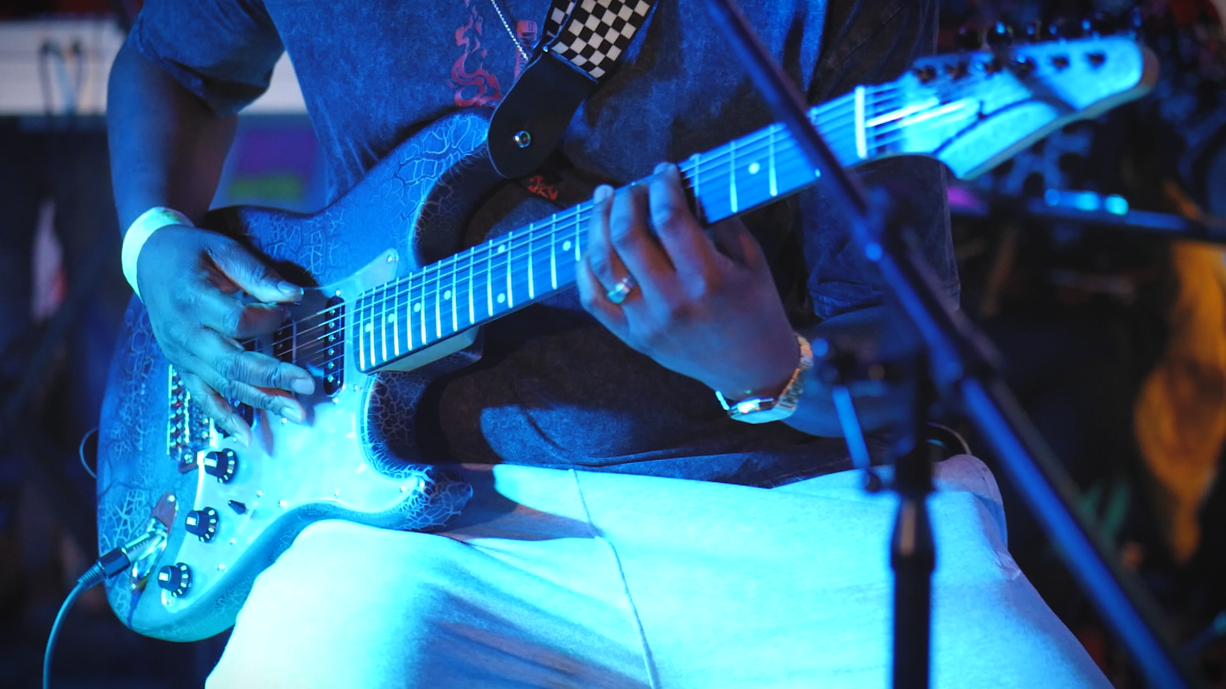 Musician playing electric guitar during a live Xpression Studio Series performance.
