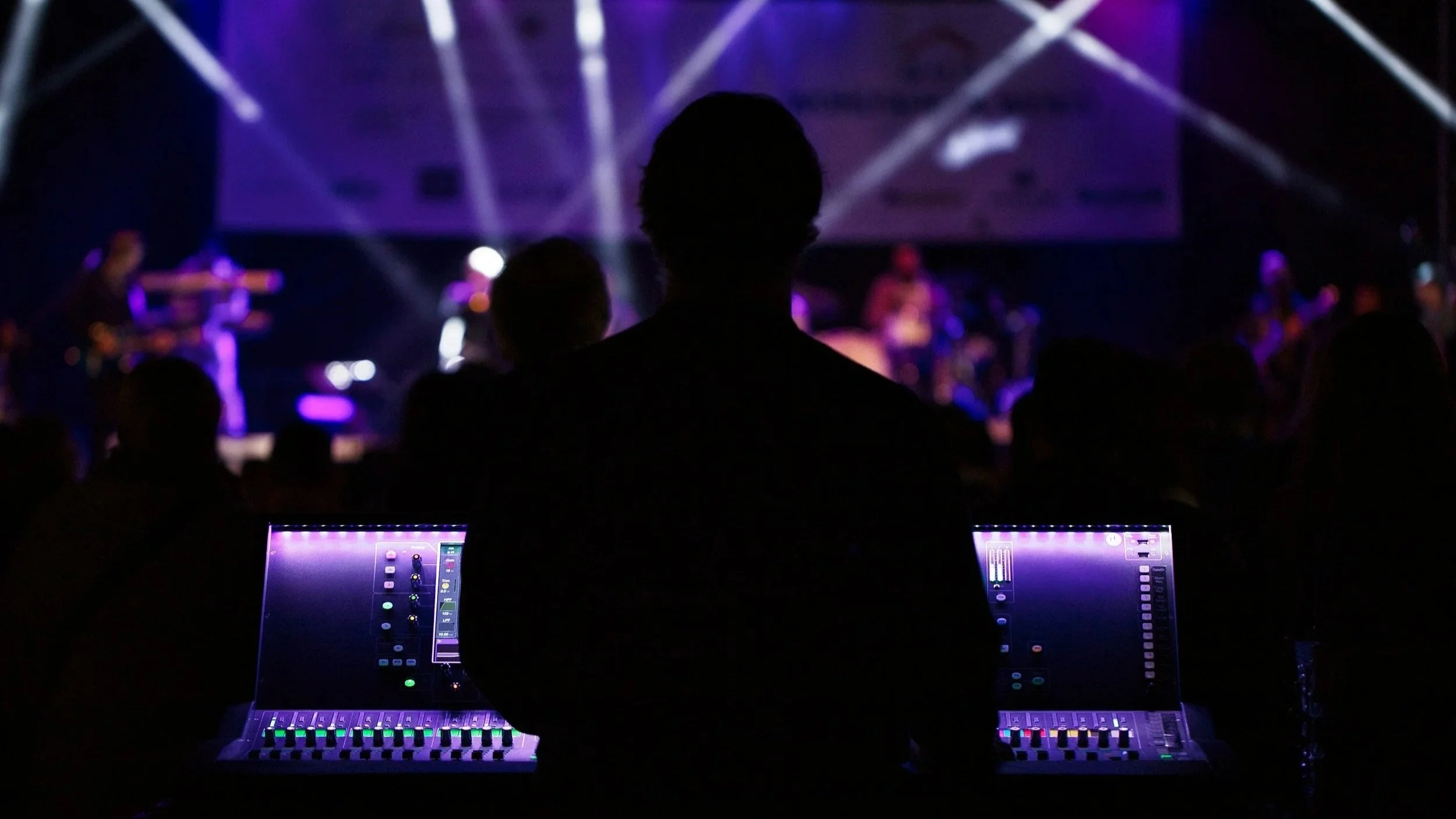 Live event technician operating a professional audio mixing console during a stage production.