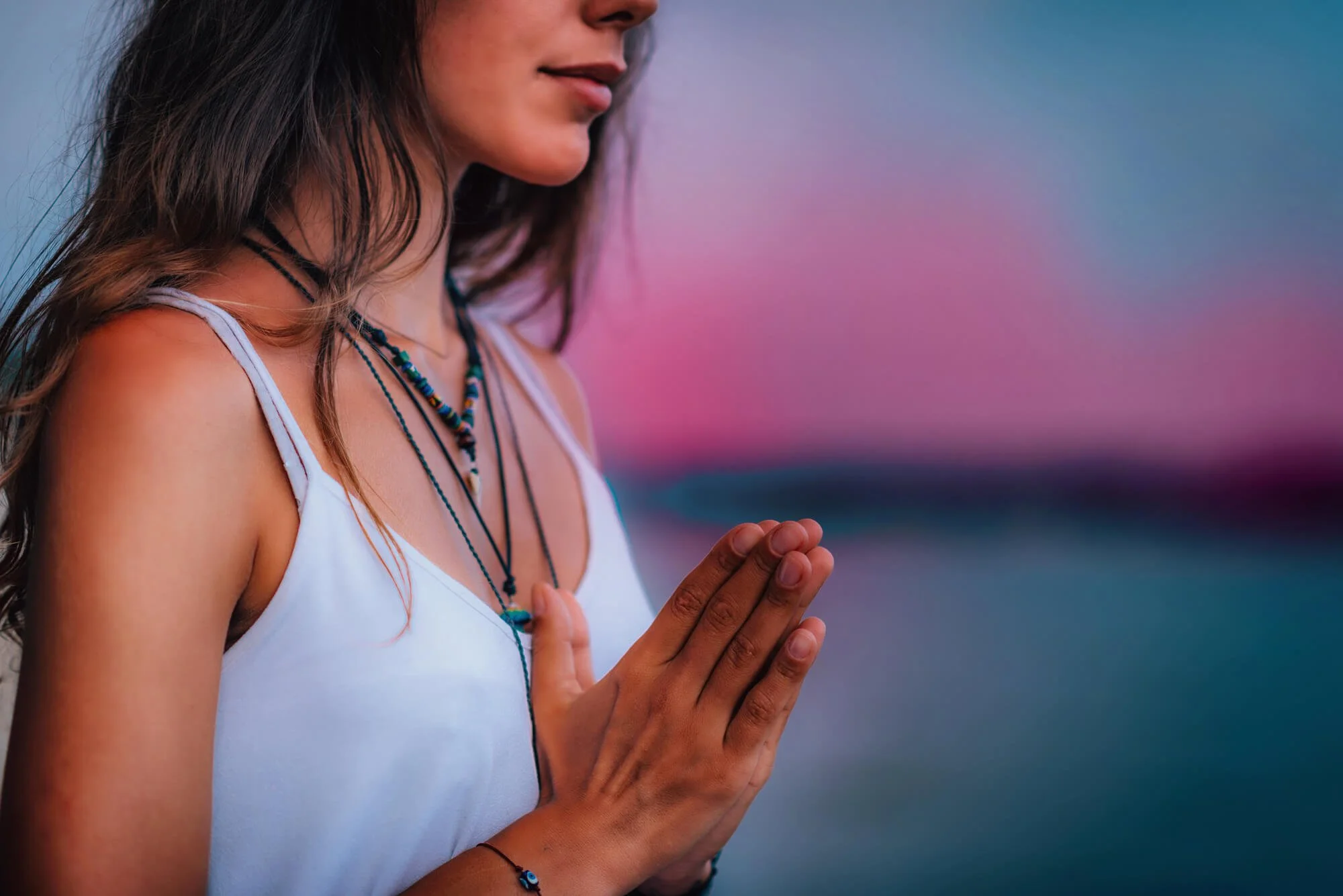 Woman praying and reflecting outdoors, representing faith and spirituality counseling in Atlanta and Dunwoody, GA.