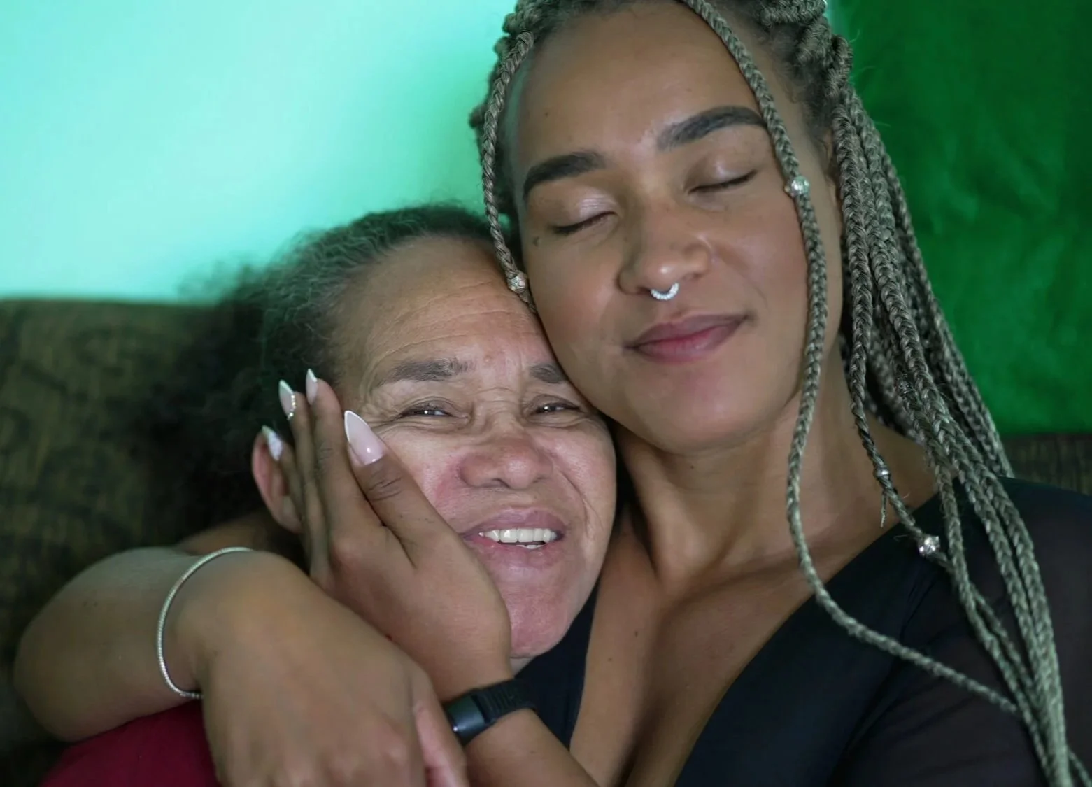 Two Black women embracing at home, representing family connection and support in family therapy in Atlanta.