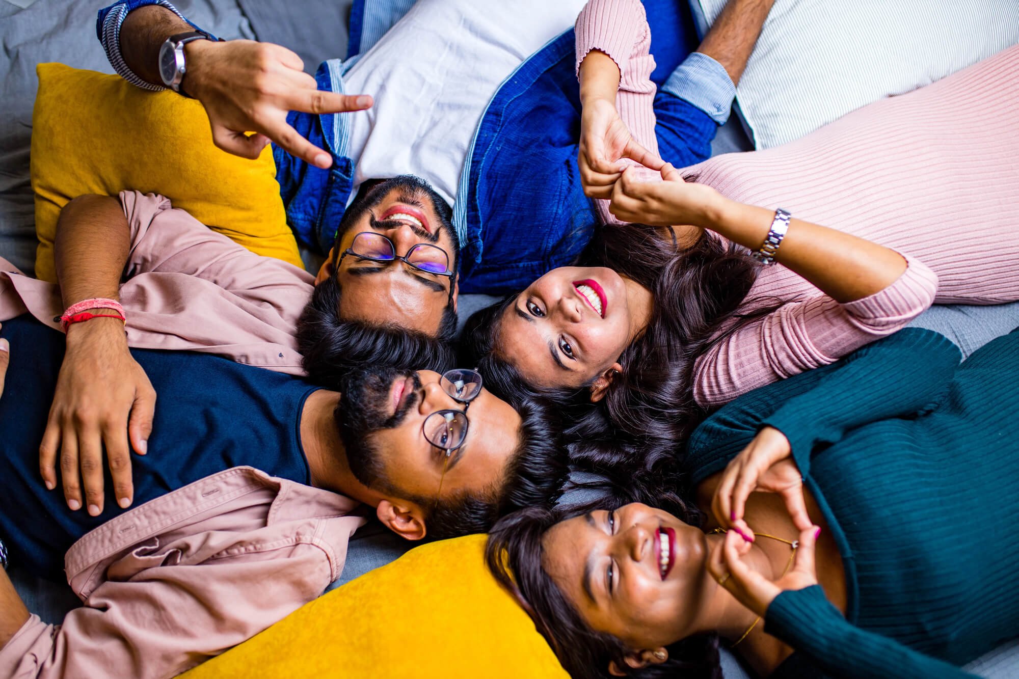 Diverse BIPOC adults lying together and smiling, representing culturally affirming therapy in Atlanta