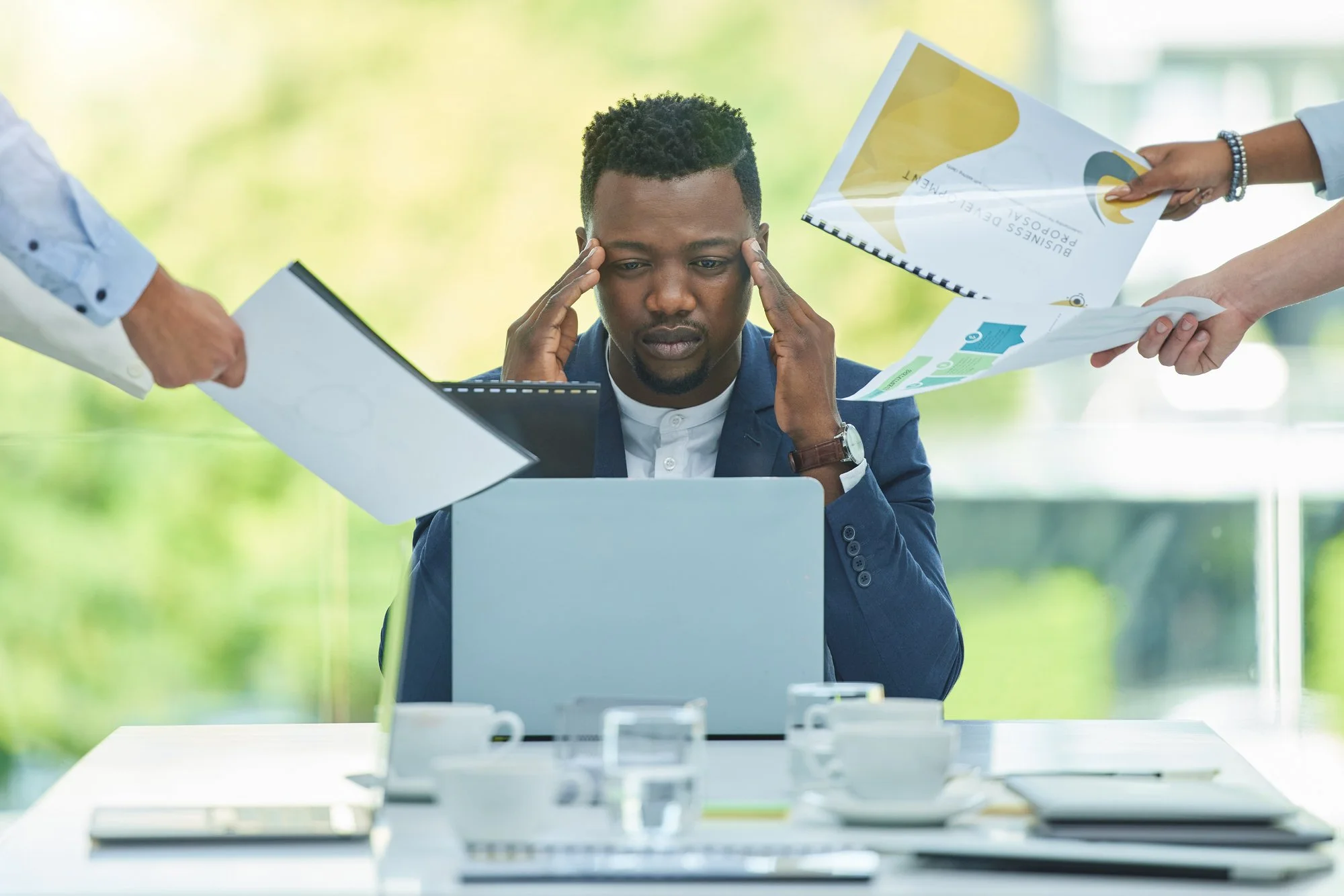 Man stressed at work desk with family photo highlighting work-life balance struggles