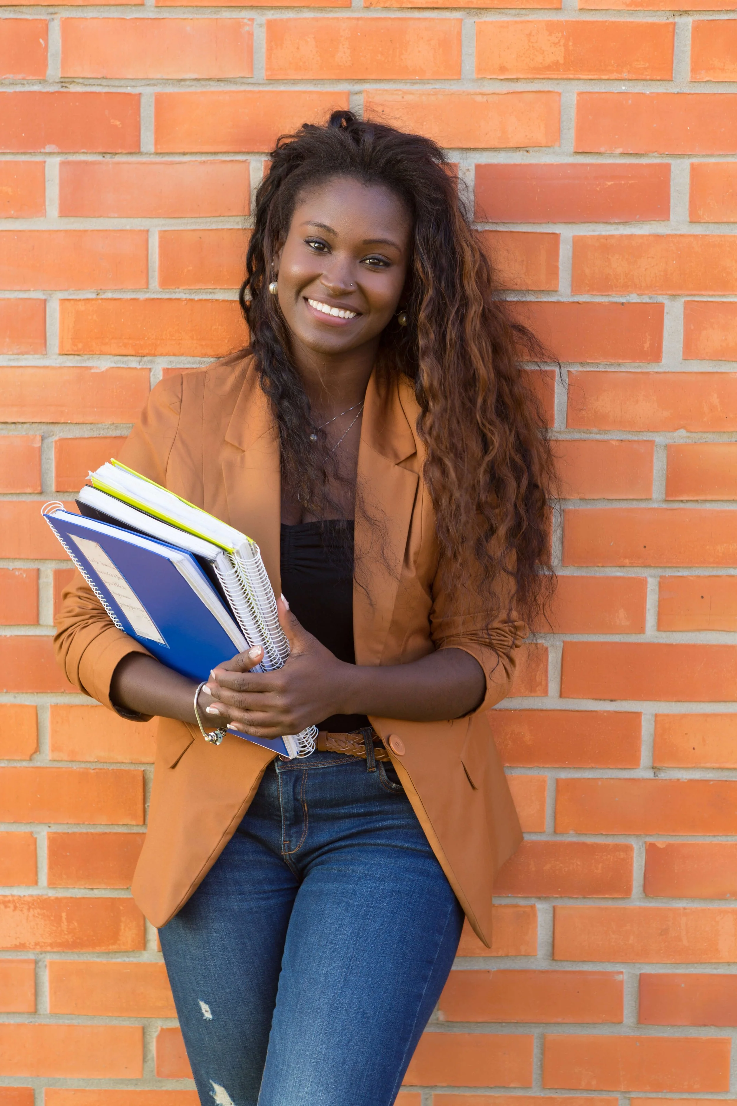Black female college student holding notebooks for student therapy and counseling in Atlanta.