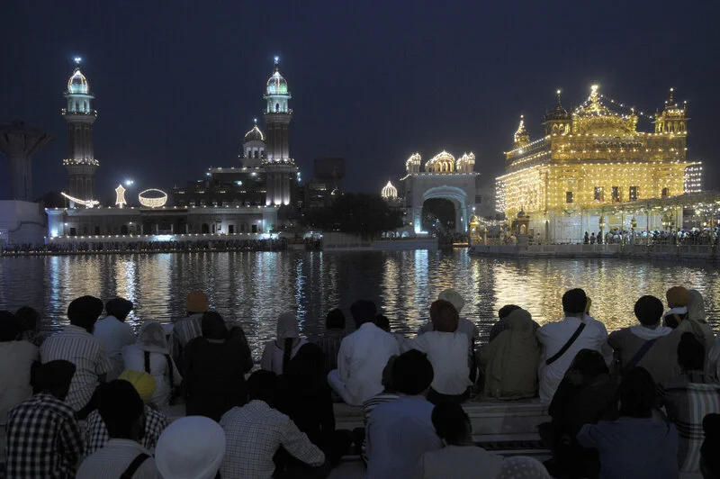  Devotees enjoy the peaceful atmosphere sitting in the parikarma of beautifully illuminated Golden Temple complex on Baisakhi 