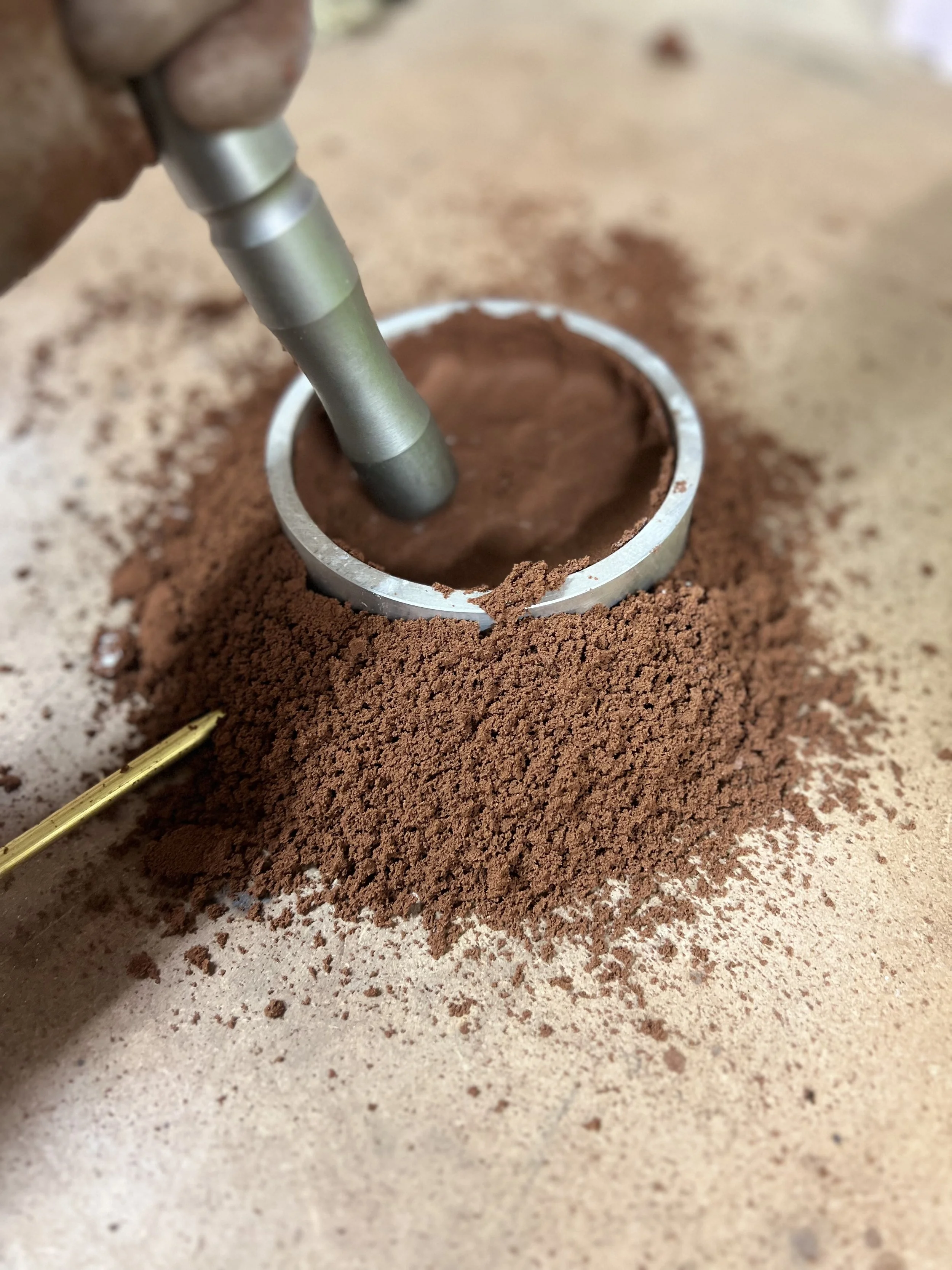 Tassement du sable dans un moule destiné à la fonte d’une poignée HANDY en laiton.