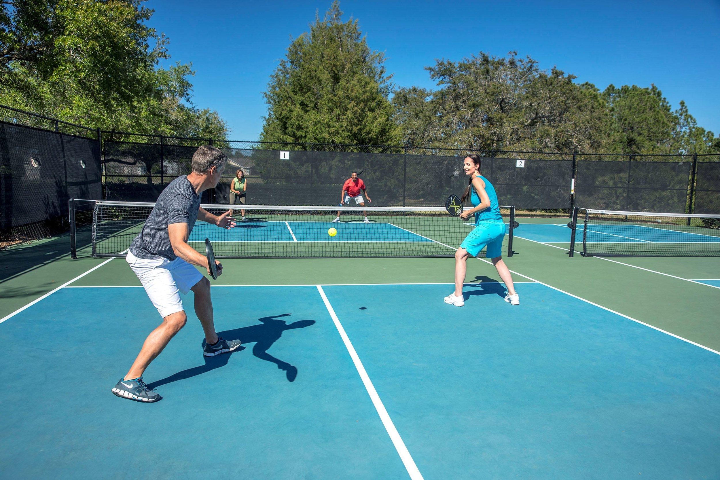 Adults playing pickleball