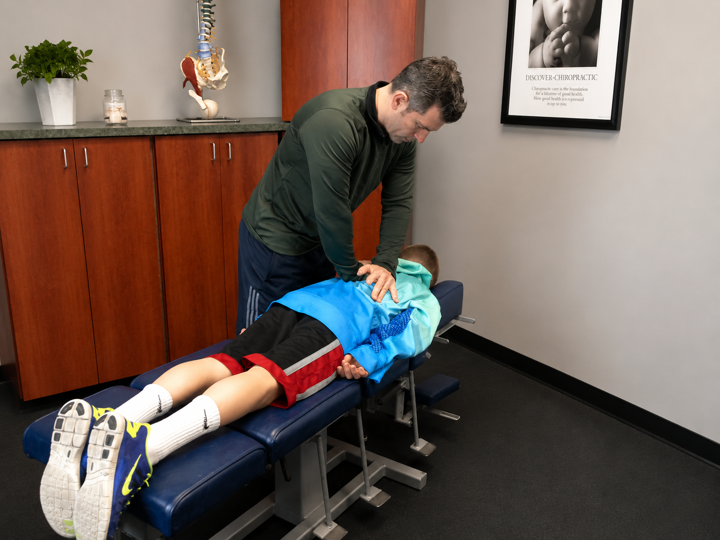 Dr. Christopher Olivieri providing chiropractic care to a patient at Olivieri Family Chiropractic in Cohasset MA