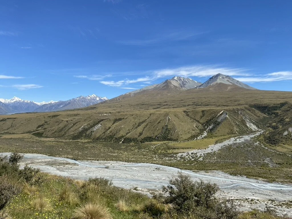 View across the Potts River. The back left mountain of the two centre  bumps is Mt Potts, the snow-capped mountains in the far distance is above the Rangitata valley.
