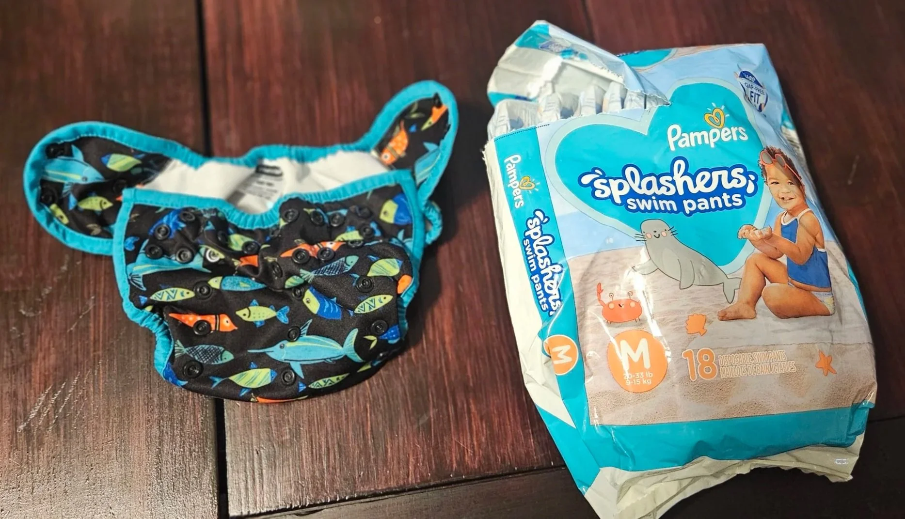 A cloth swim diaper with snaps next to a package of disposable swim diapers.