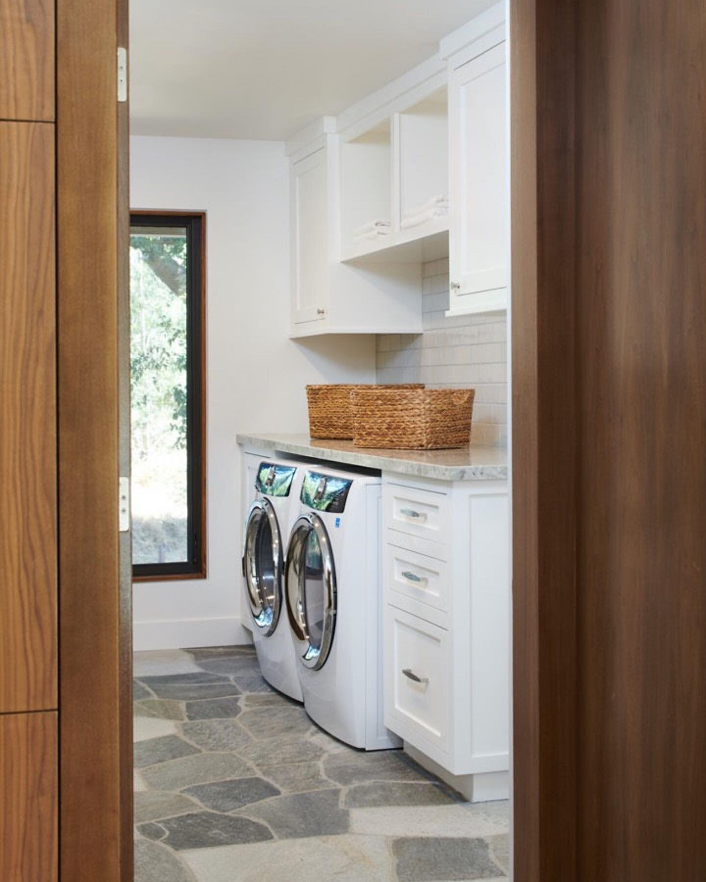 Peek into a serene laundry room with stone flooring, white cabinetry and a generous picture window looking out to the property&rsquo;s lush landscaping. 🌳 
📸: @pcv_ps 
#OnlyPrettyThings
#HomeWithStyle