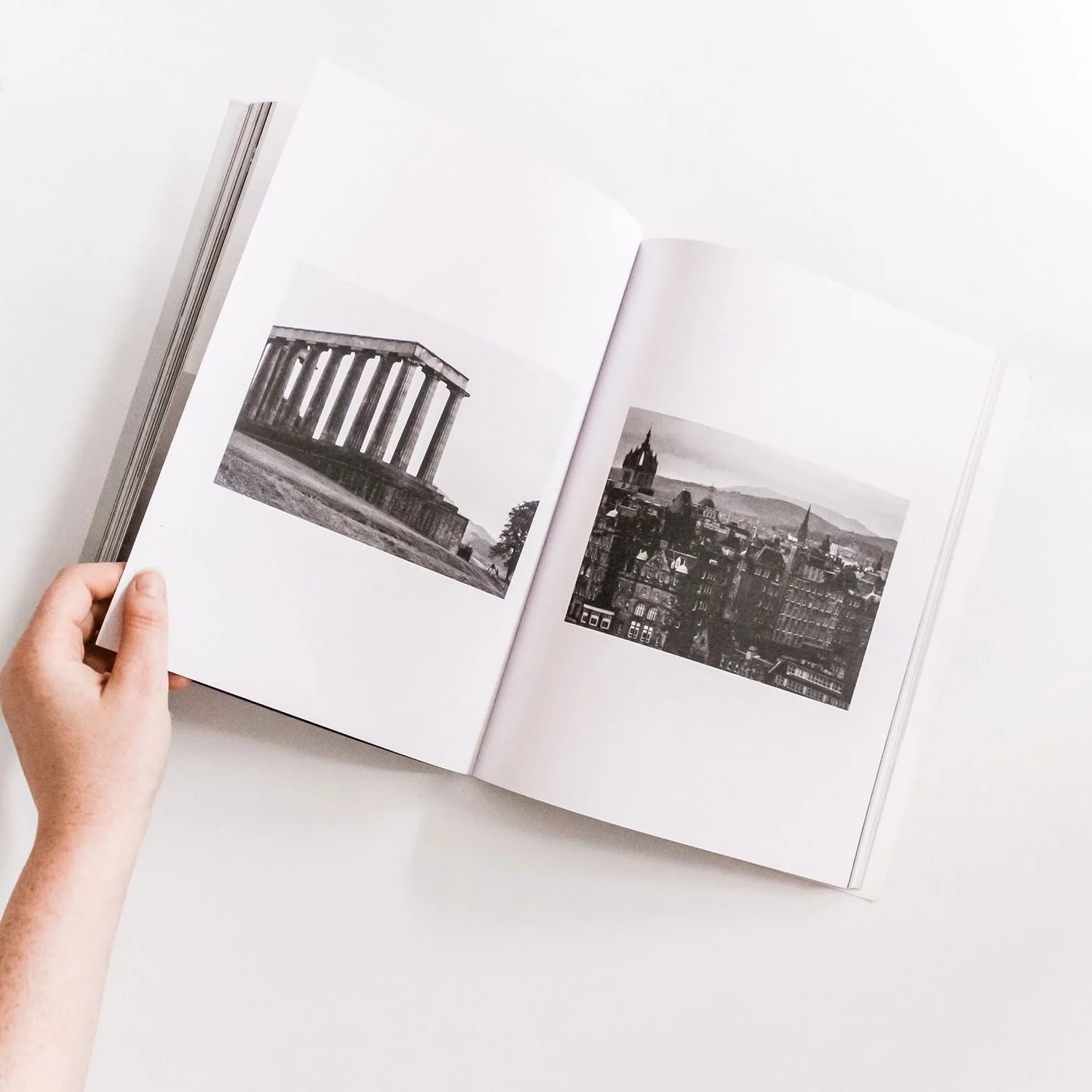 Open book showing black and white photographs of historic buildings and cityscapes.