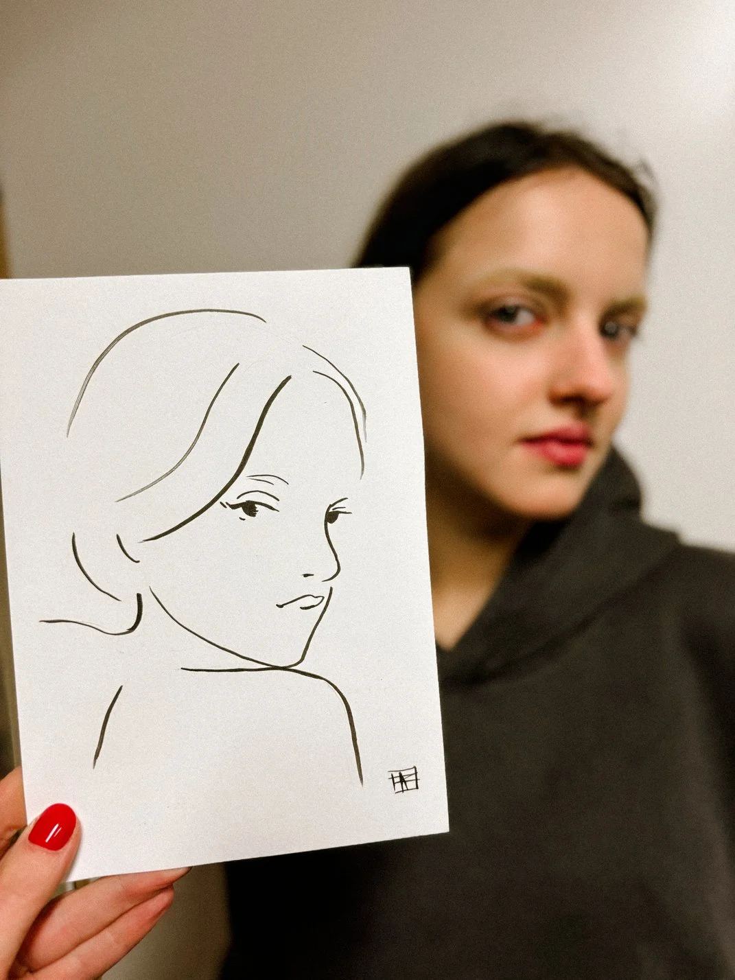 A guest of the corporate event holding a fashion portrait of herself