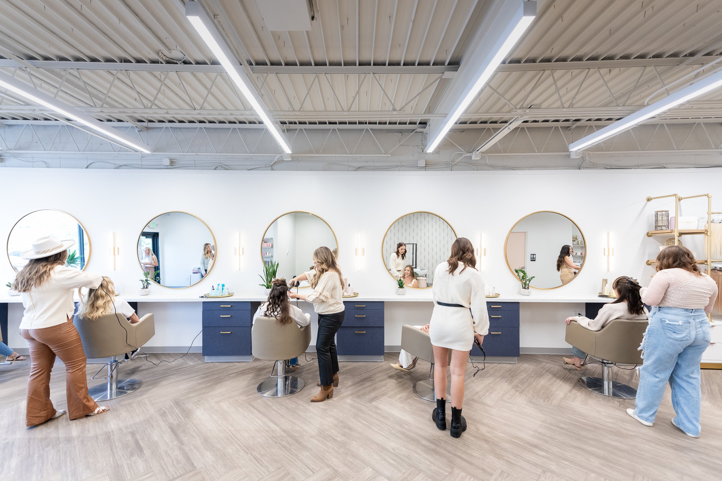 Hyde Salon team working with clients across multiple styling stations in open salon layout