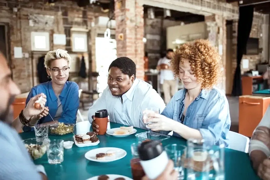 Group sharing a meal, relaxed and engaged in conversation.
