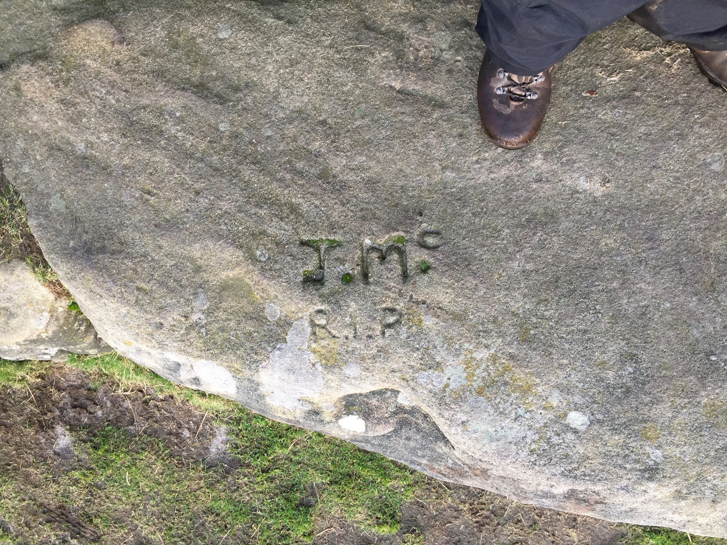  Looking down at my boots on one of the rocks, and the inscription, ‘J.Mc RIP’. 