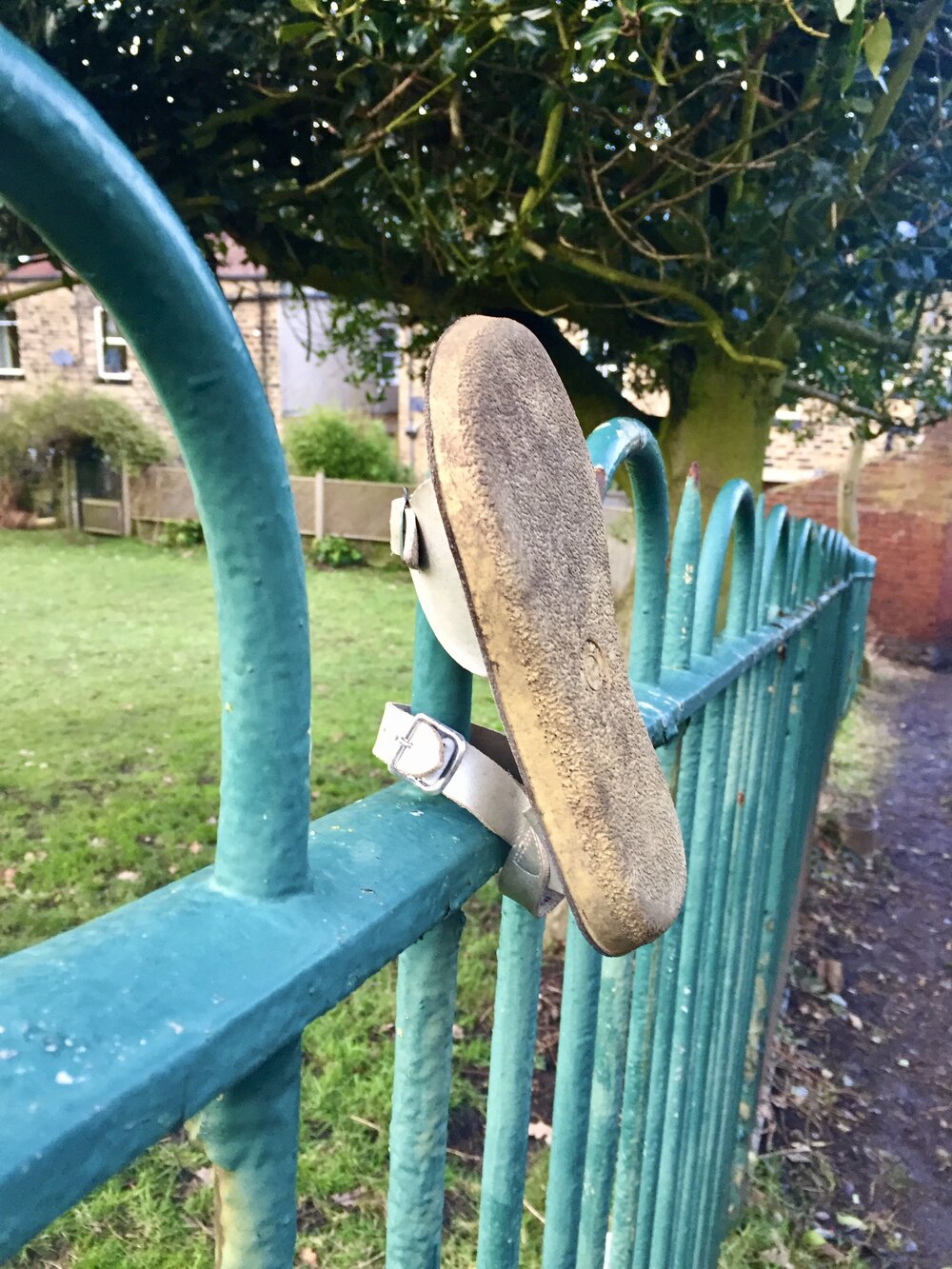  A sandle mounted on a fence. It might be a child’s, but it’s hard to say. Regardless, it’s winter and every aspect of this is inconceivable. 
