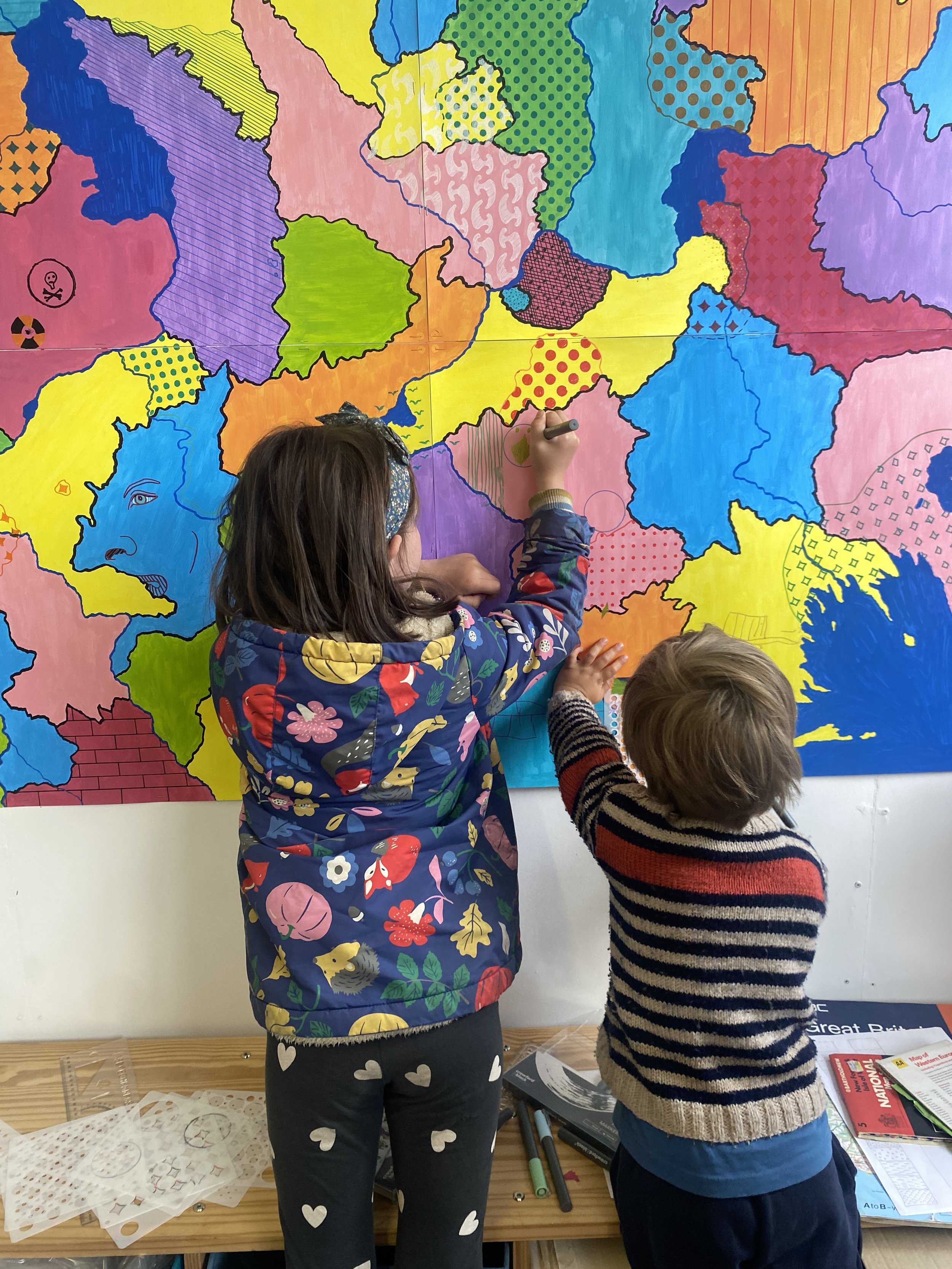  Two children adding symbols, patterns and bananas. 