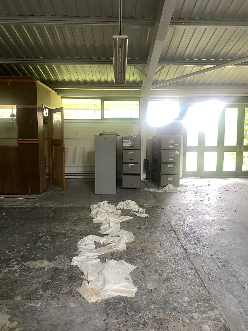  In the same room, a security booth has been installed at the front of the building, next to a gathering of several filing cabinets. 