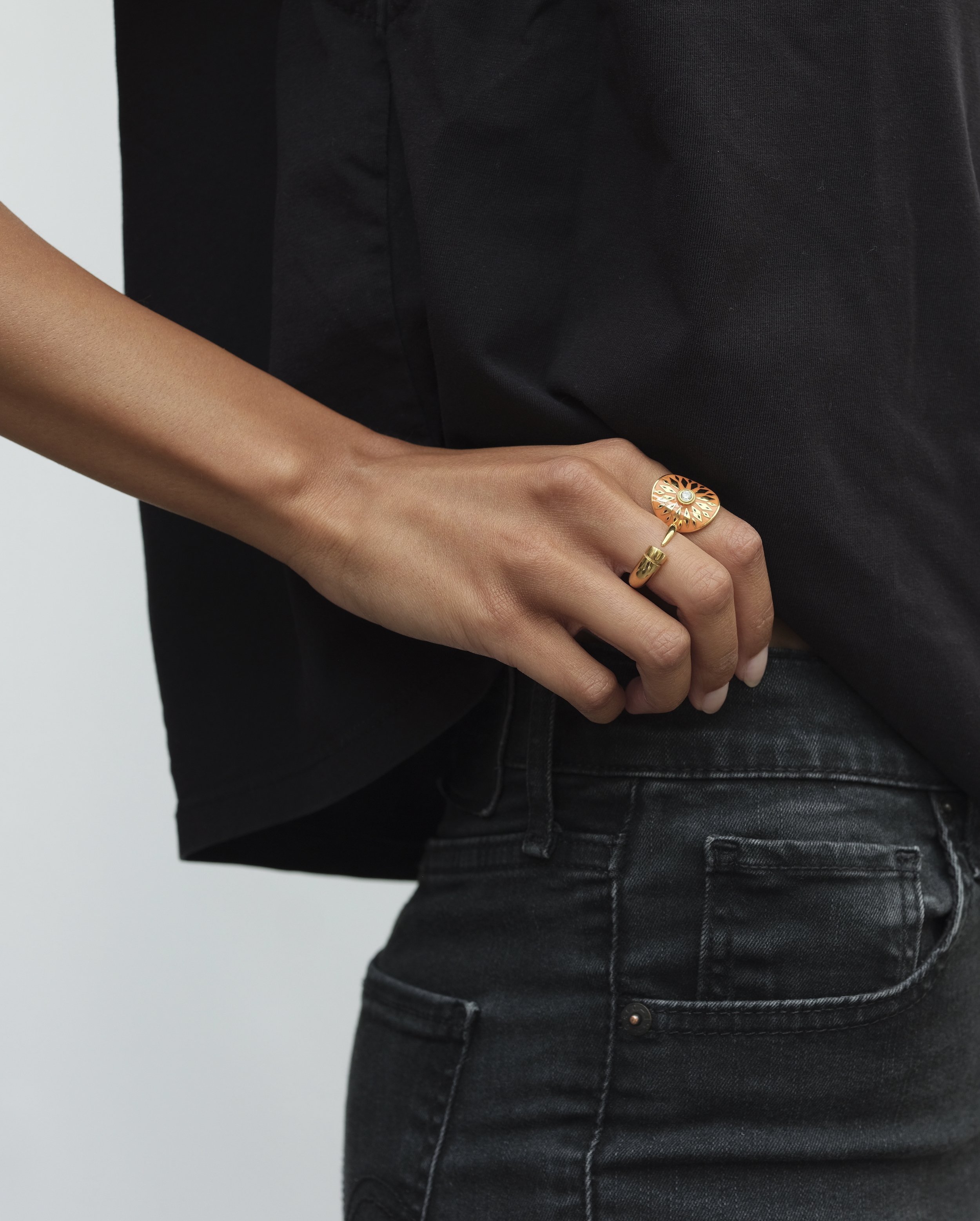 Model wears Beabond Mokola Kudu Ring 14k recycled yellow gold with diamond and orange enamel