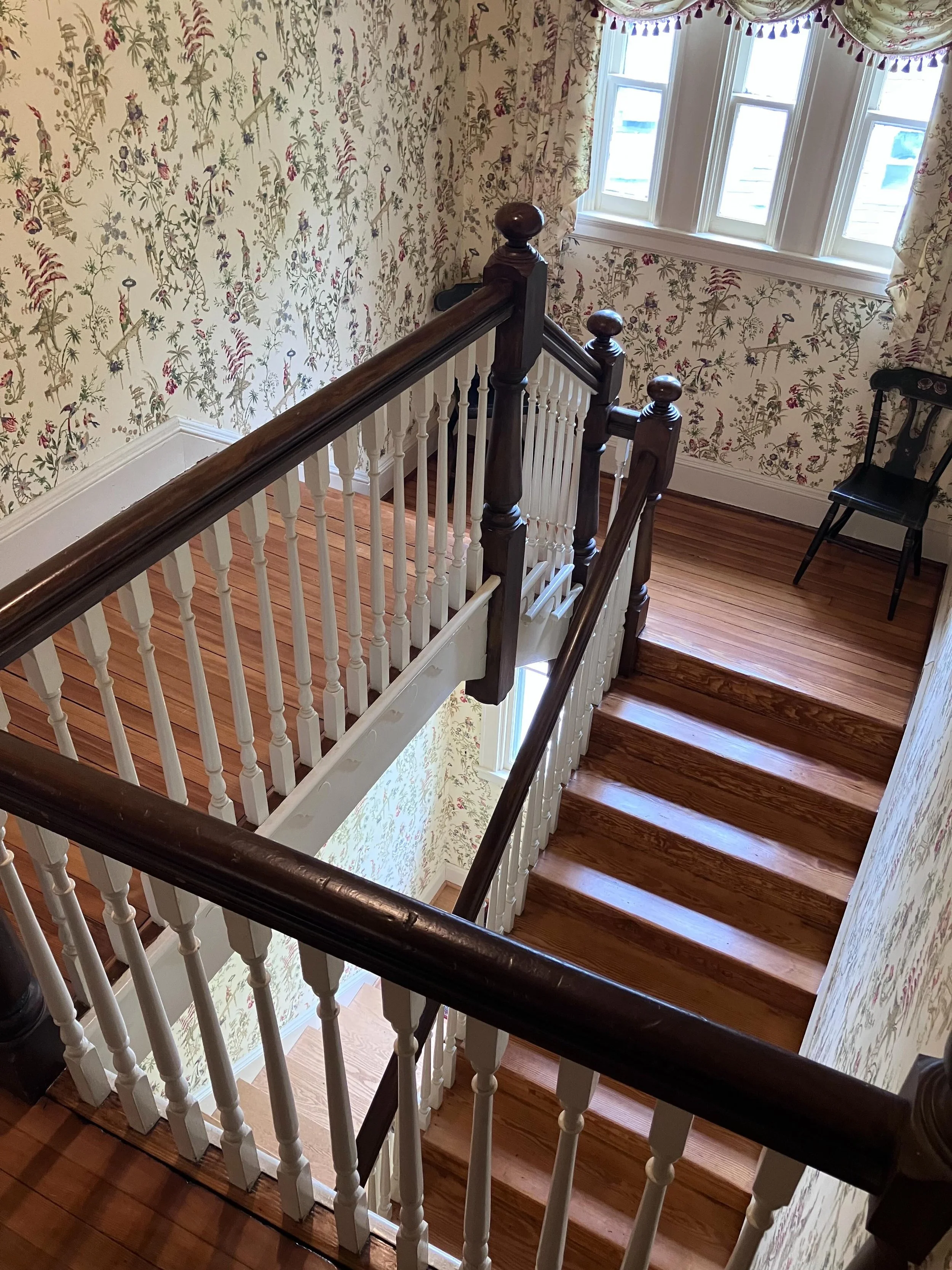 Sunday staircase.

I love the softness of the light in this spot, the simple wood tones with white trim, and the extended walkway that meets the first set of steps down before the landing.  What a great place to pause and appreciate seeing 3 floors d