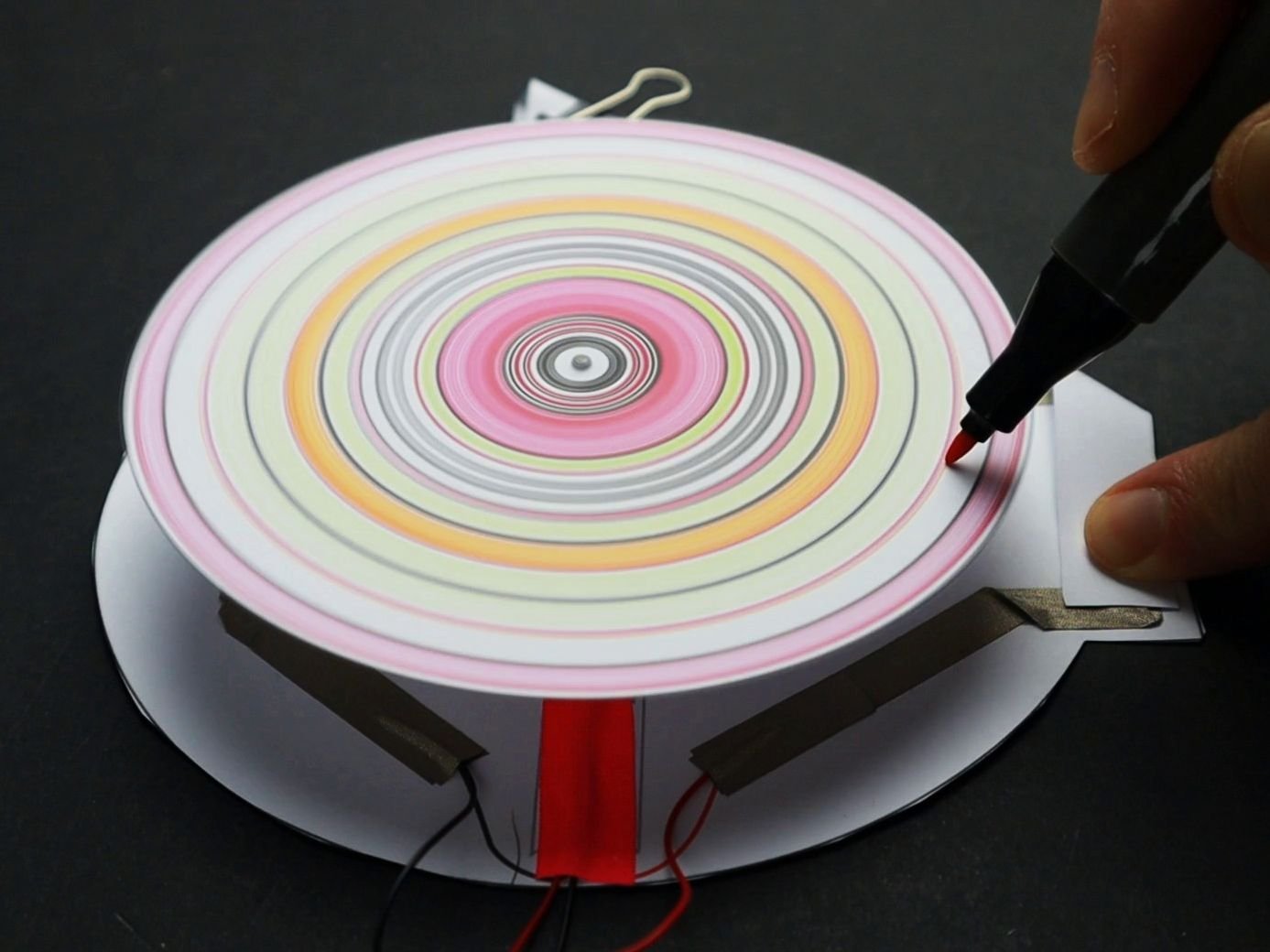 spinning art robot with red black and green