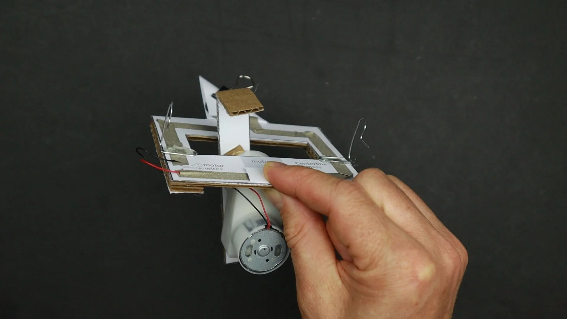 a picture of the chameleon robot chassis made from cardboard, conductive tape and a geared motor.