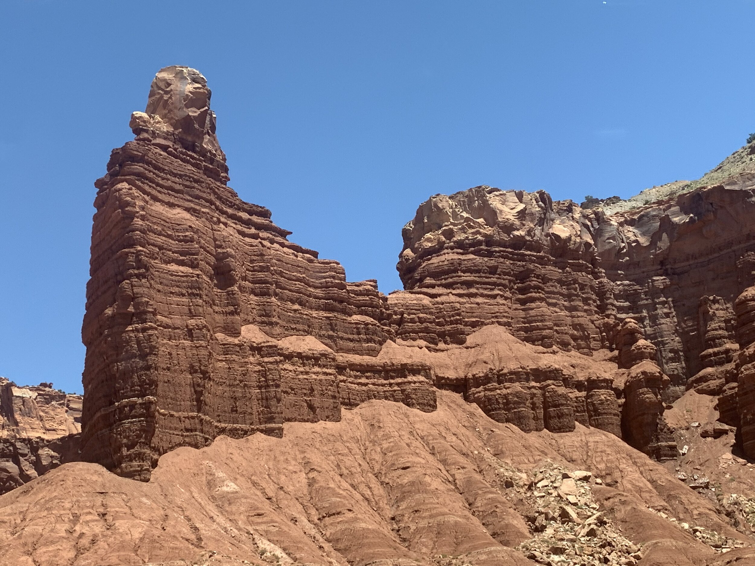  The sandstone is relatively soft, so when the rains do come, little by little, it washes the sandstone to the base of the structures. The sandstone at the base of Chimney Rock, is the result of rain over the course of millions of years.  