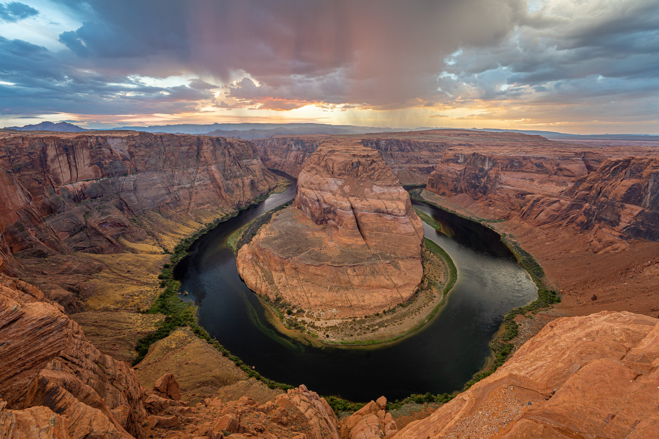  For anyone who has never been to  Horseshoe Bend in Page, Arizona , the circular, “horseshoe” route of the Colorado River is much bigger than it looks in photographs. Kayakers 1,000 feet down look like tiny toothpicks from the top rim. A storm was b
