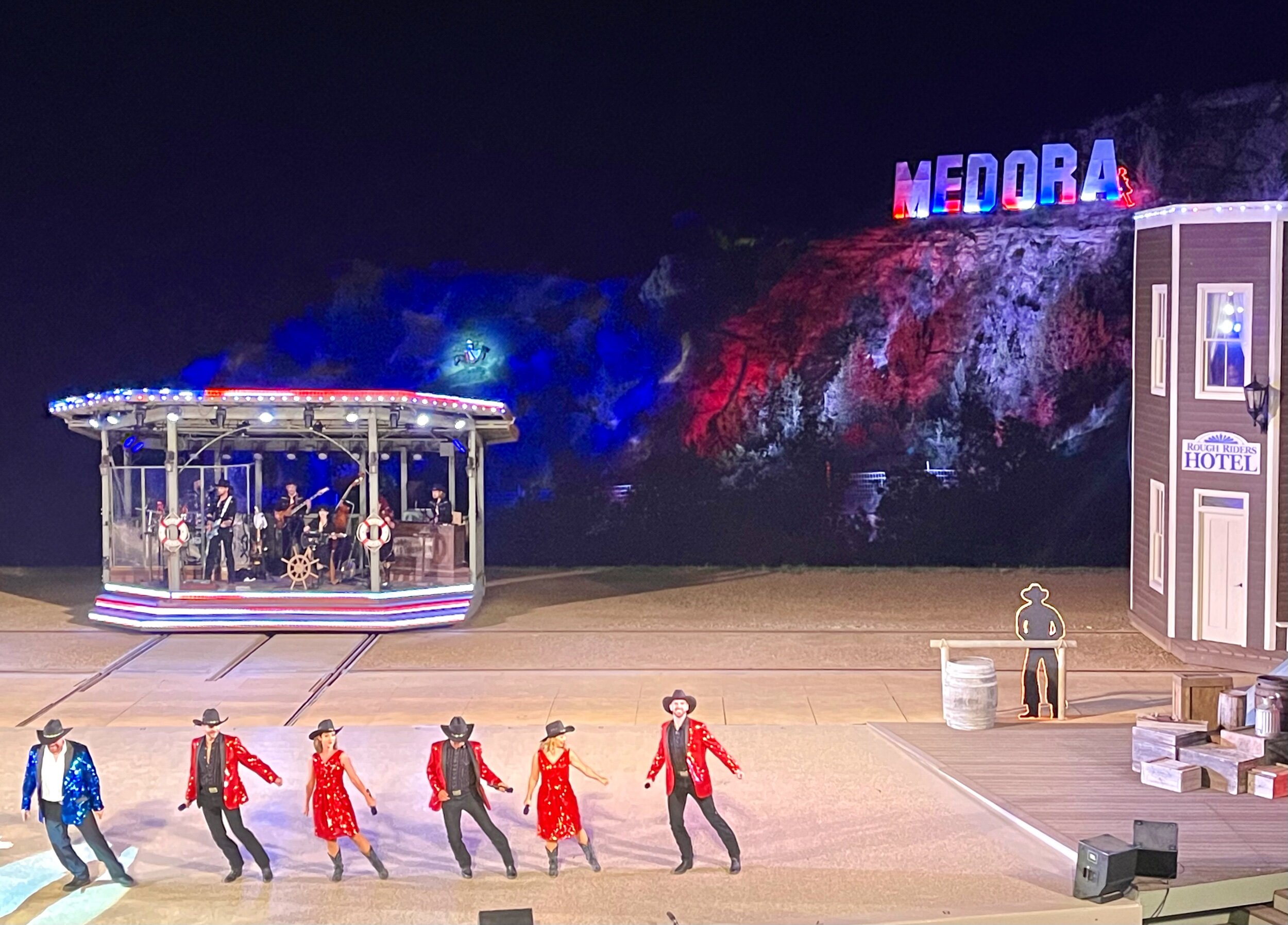  During the grand finale, a lone horse and its rider (spotlighted just above the smaller band stage in this photo) ascended an actual mountain behind the set to the top of the MEDORA sign. Meanwhile, the rest of the cast sang, played, and danced thei