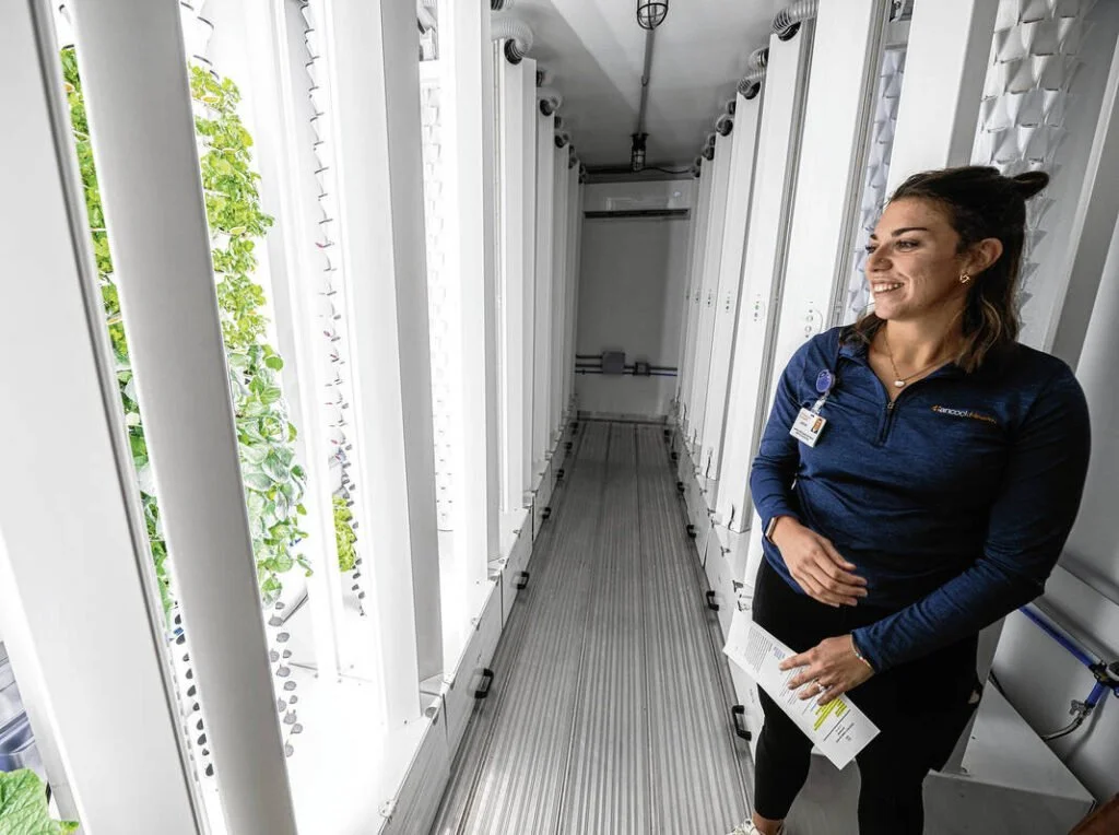 aici Wright, clinical dietitian at Hancock Wellness Center, stands by anu’s hydroponic container farm supporting Hancock Health’s Food is Medicine program. Photo: Tom Russo, Daily Reporter.