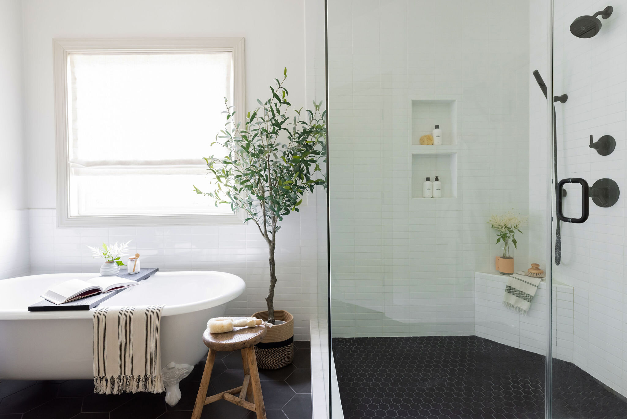 Modern organic black and white bathroom with clawfoot tub by Lauren DeBello Interiors