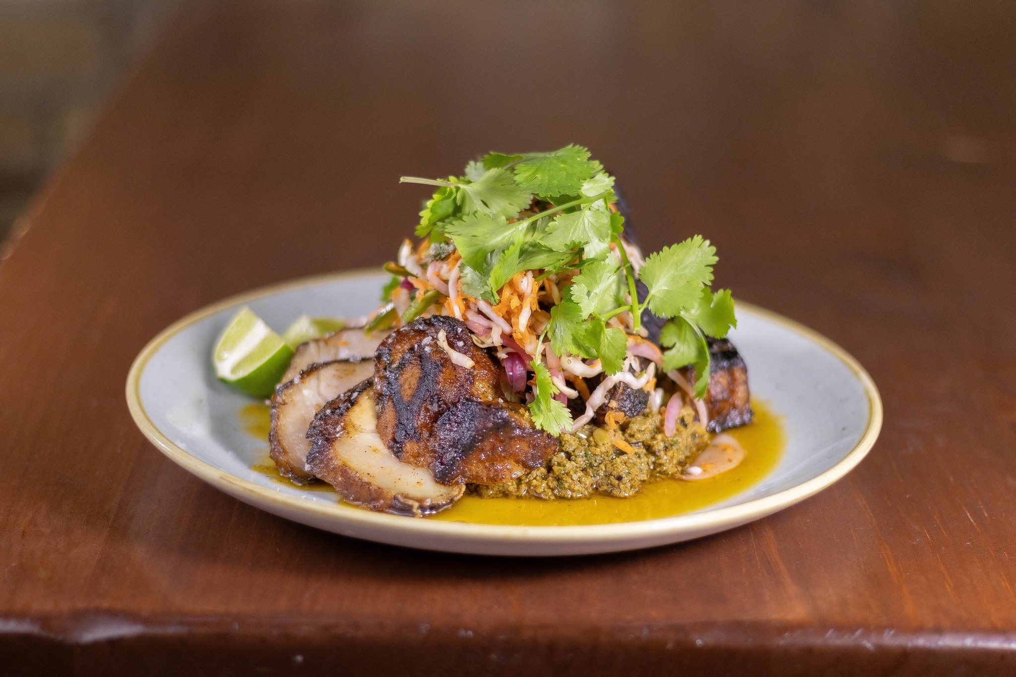 Our new pork chop is marinated in al pastor spice, grilled &amp; glazed with agave, habanero &amp; citrus. It's served with a pepita &amp; tomato sikil p'ak and pickled carrot &amp; cabbage curtido. Available at dinnertime daily 🔥