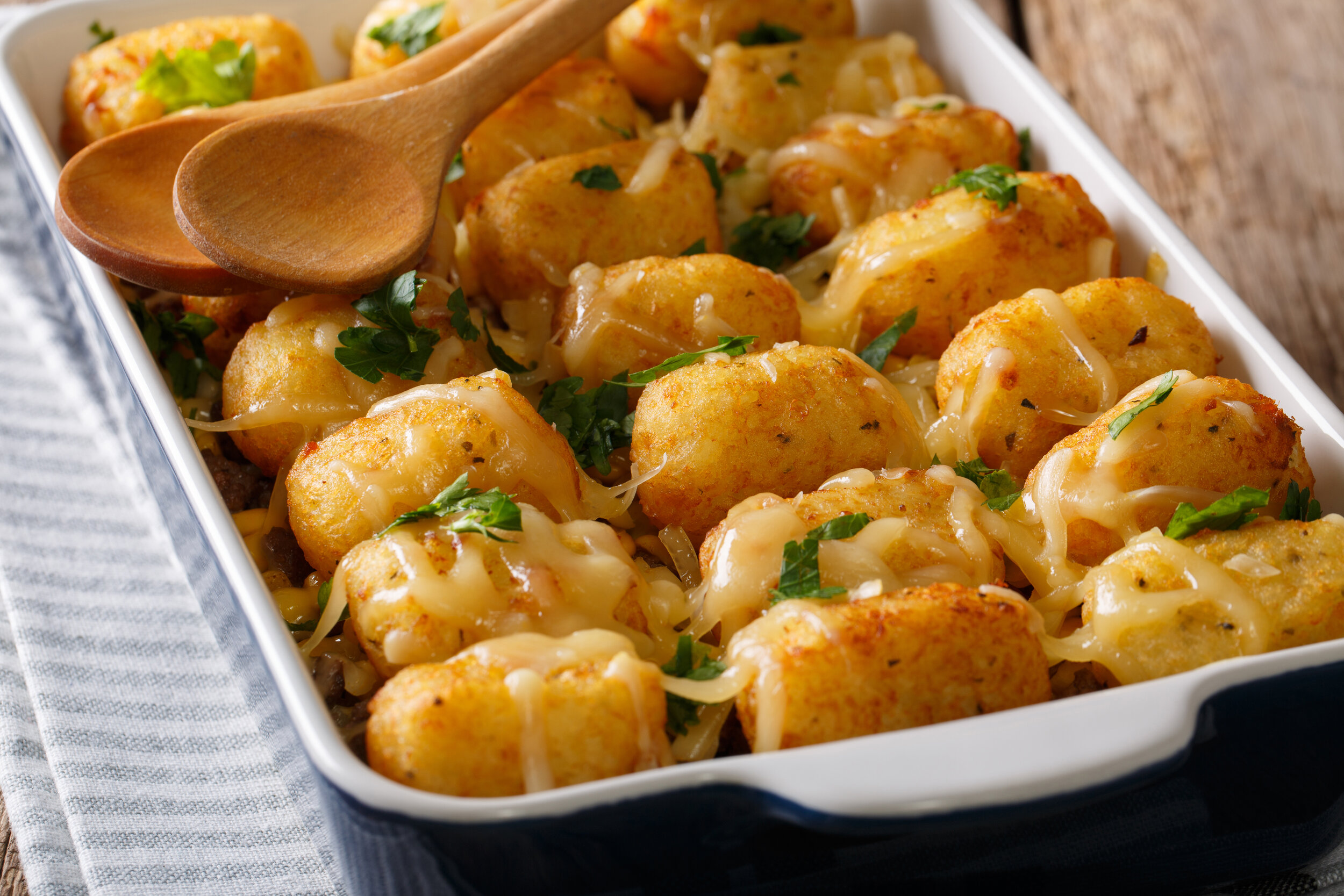 Canva - Hot Baked Tater Tots with cheese, meat, corn and parsley close-up in on the table. horizontal.jpg