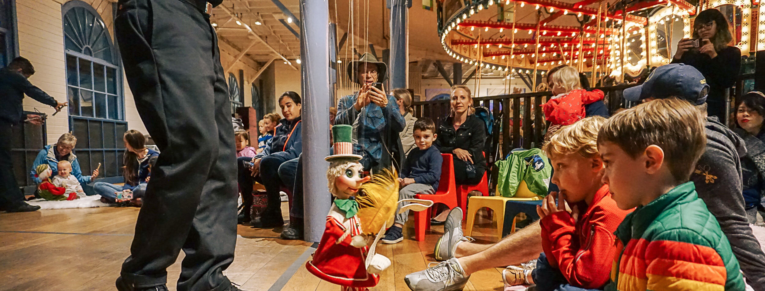 Children watching puppet show in Carousel building