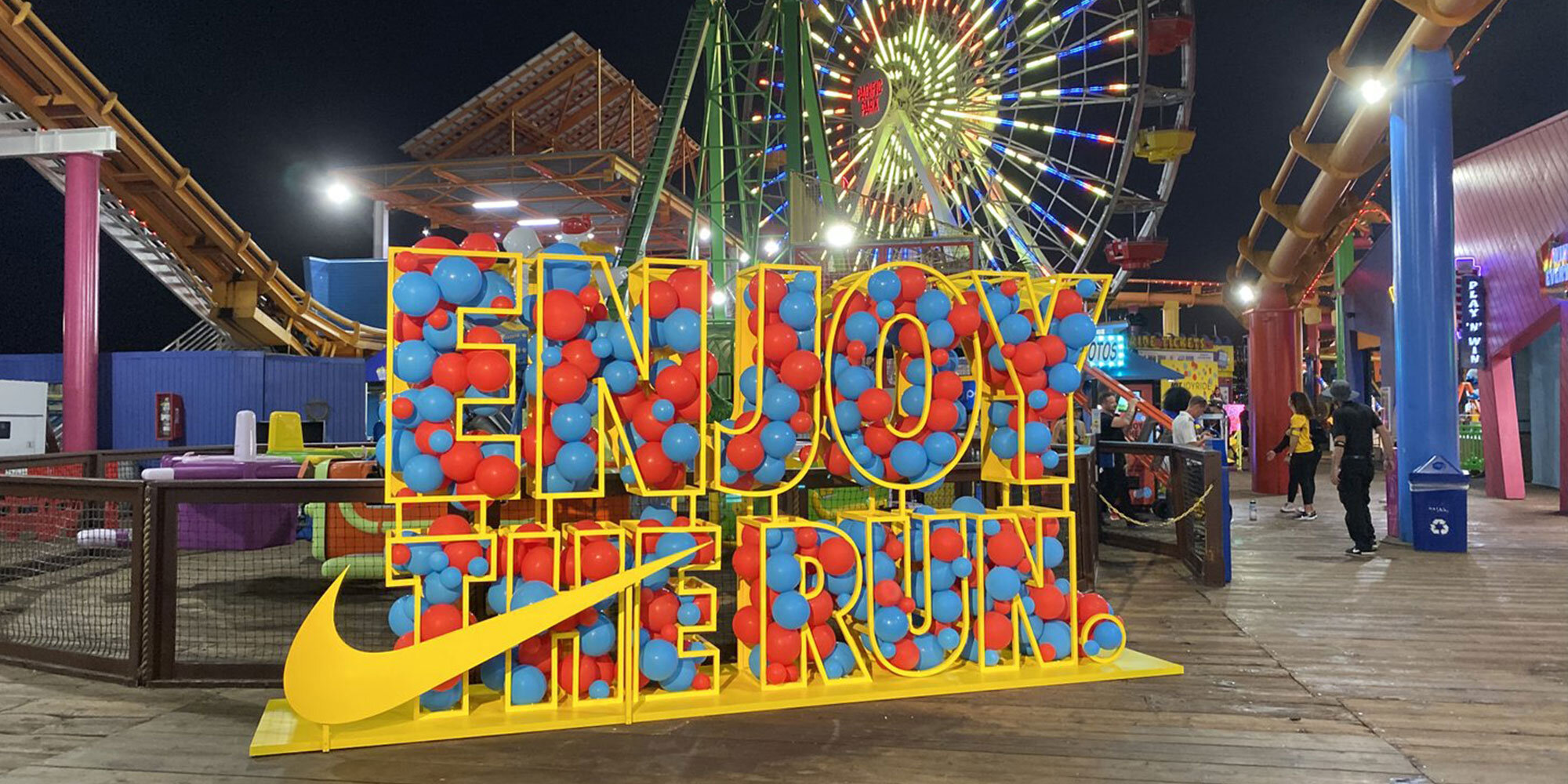 Large Nike display sign filled with red and blue balloonsthat reads "Enjoy the Run"