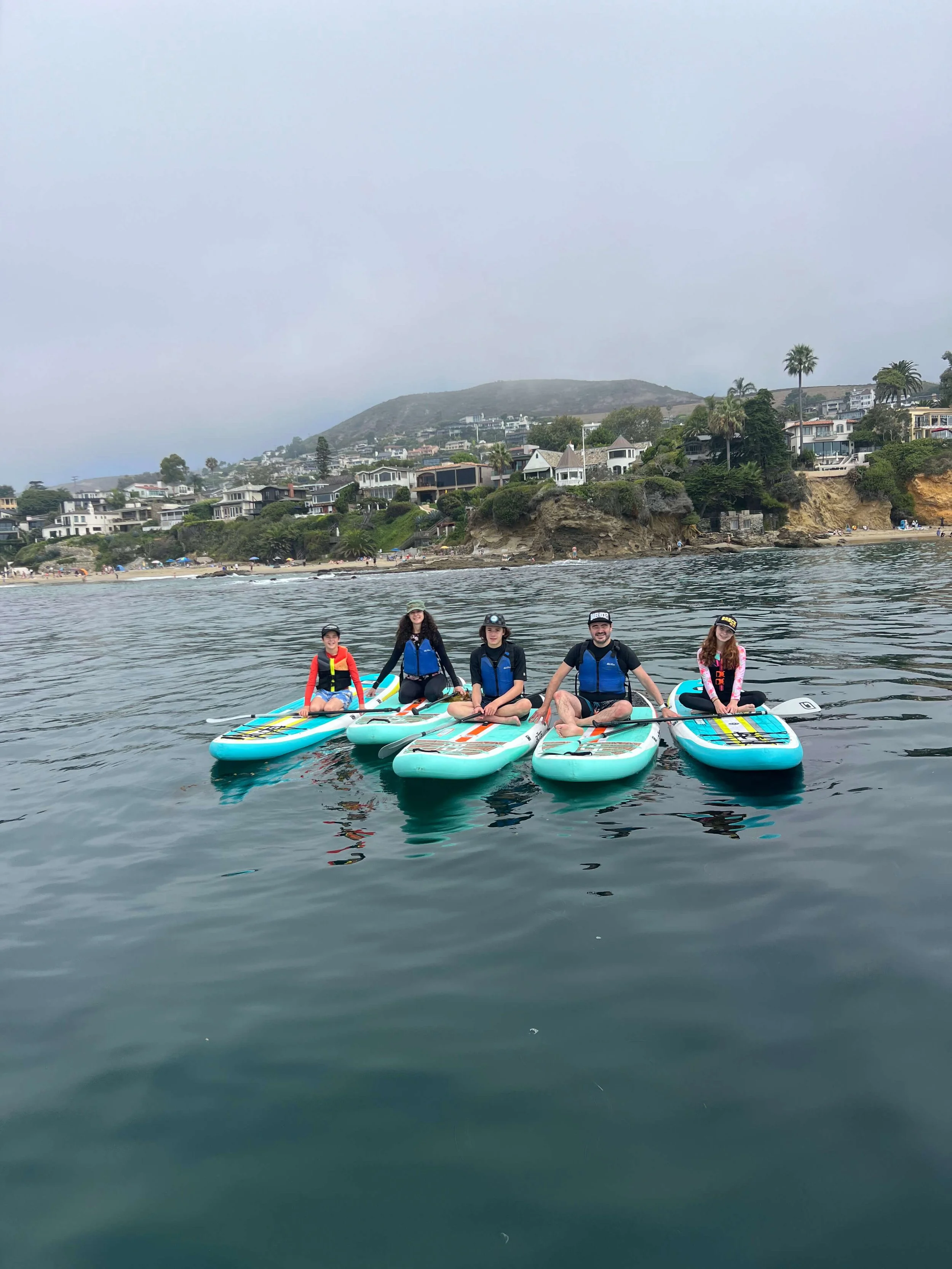 Group posing on the water during a stand up paddle boarding tour of laguna beach, Ca.jpg