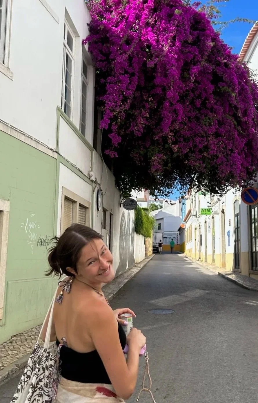 Intern Simone standing in front of a purple flowering bush