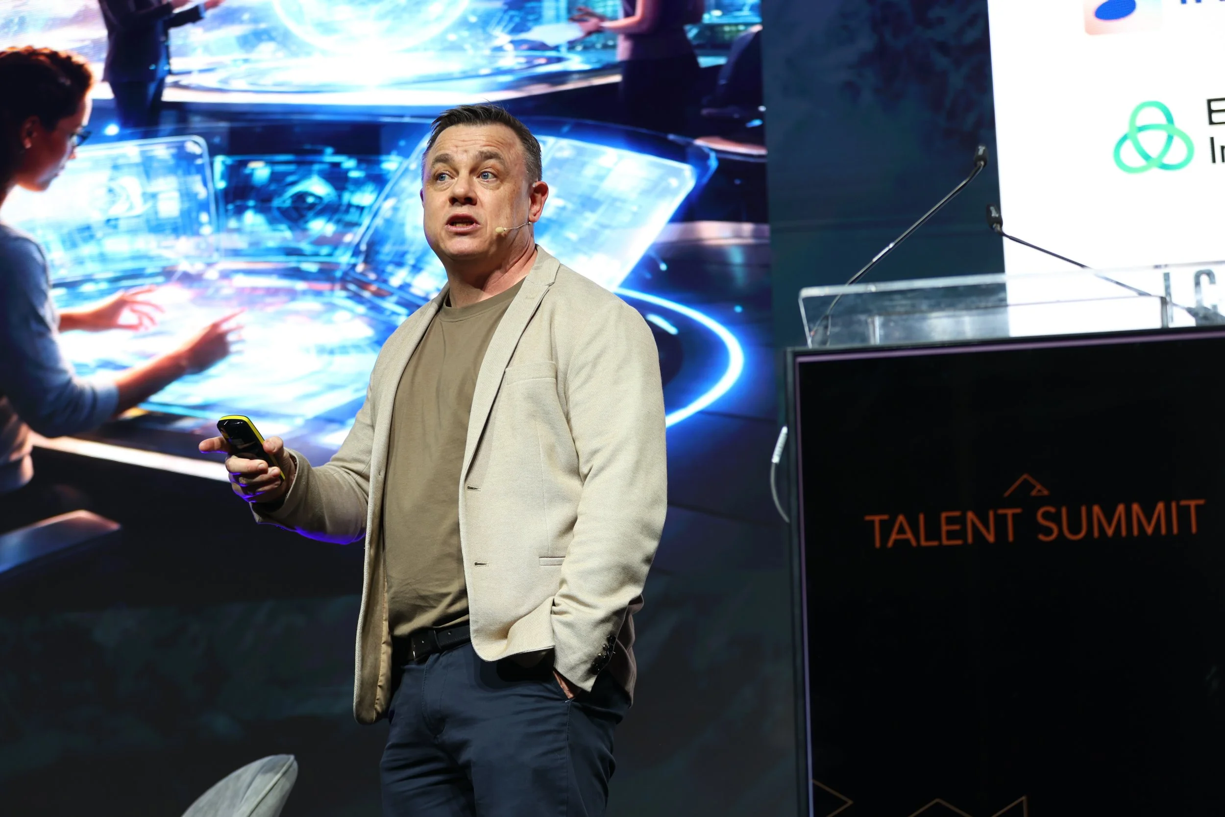 Image of Rossa Mullally speaking at Talent Summit 2026 in front of a futuristic background