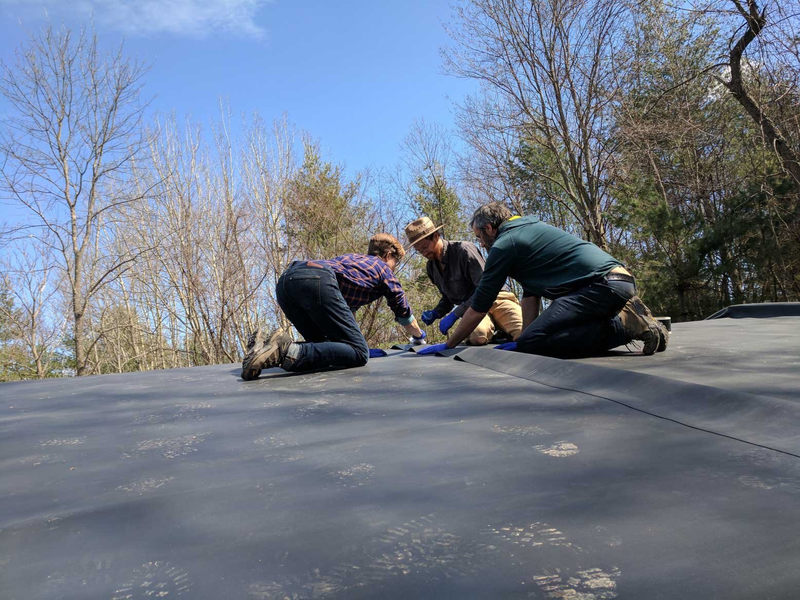  On the roof gluing the seam of the pond liners together with Ray, Michael, and John. 