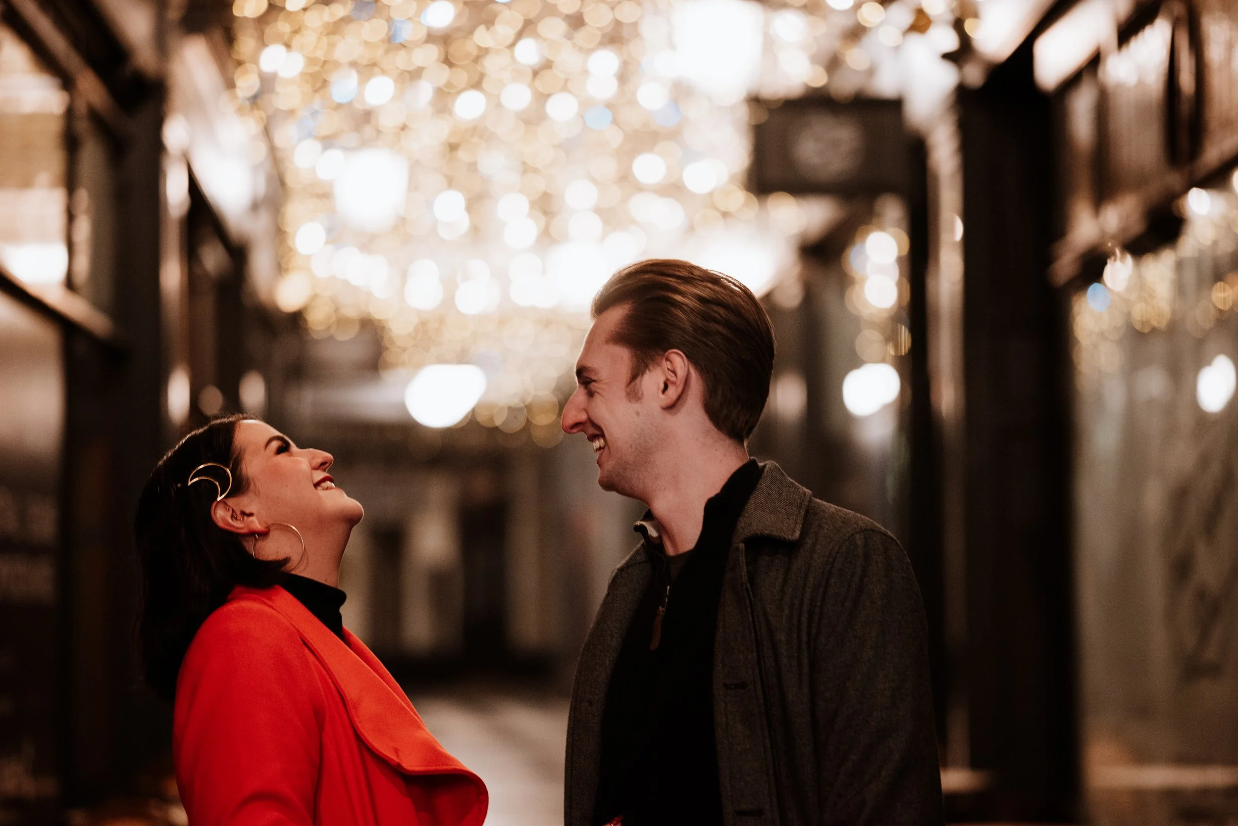 mand and woman share a joke during night time engagement shoot in Cardiff