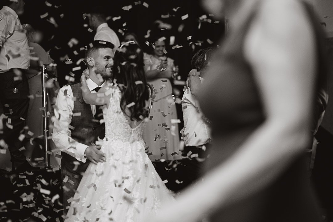 black and white image of a bride and groom first dance during a confetti canon