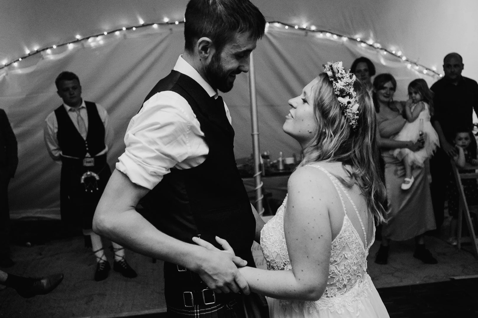 black and white image, close up, of a bride and groom having their first dance and looking at eachother