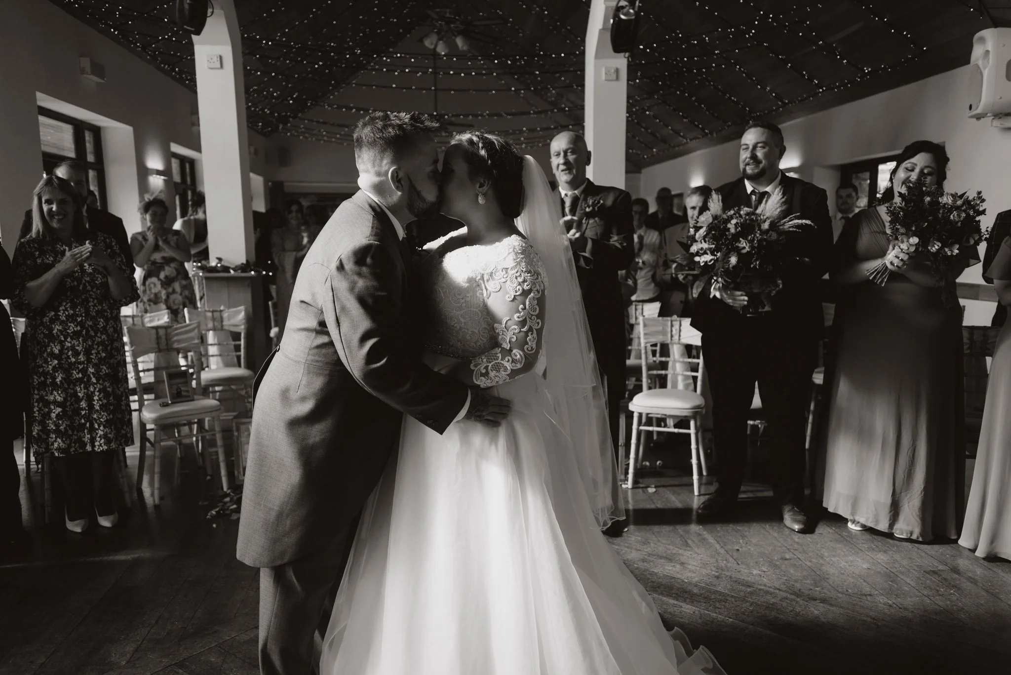 black and white first kiss image at a wedding in Canada lodge lake in Cardiff.