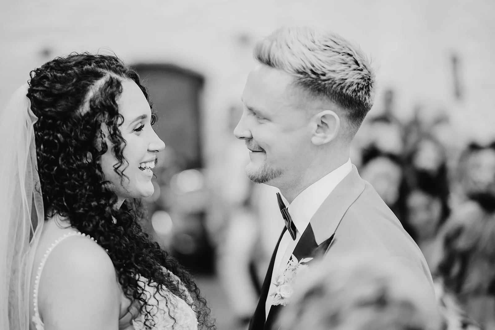 black and white image of a bride and groom smiling at each other during their wedding ceremony in Bristol